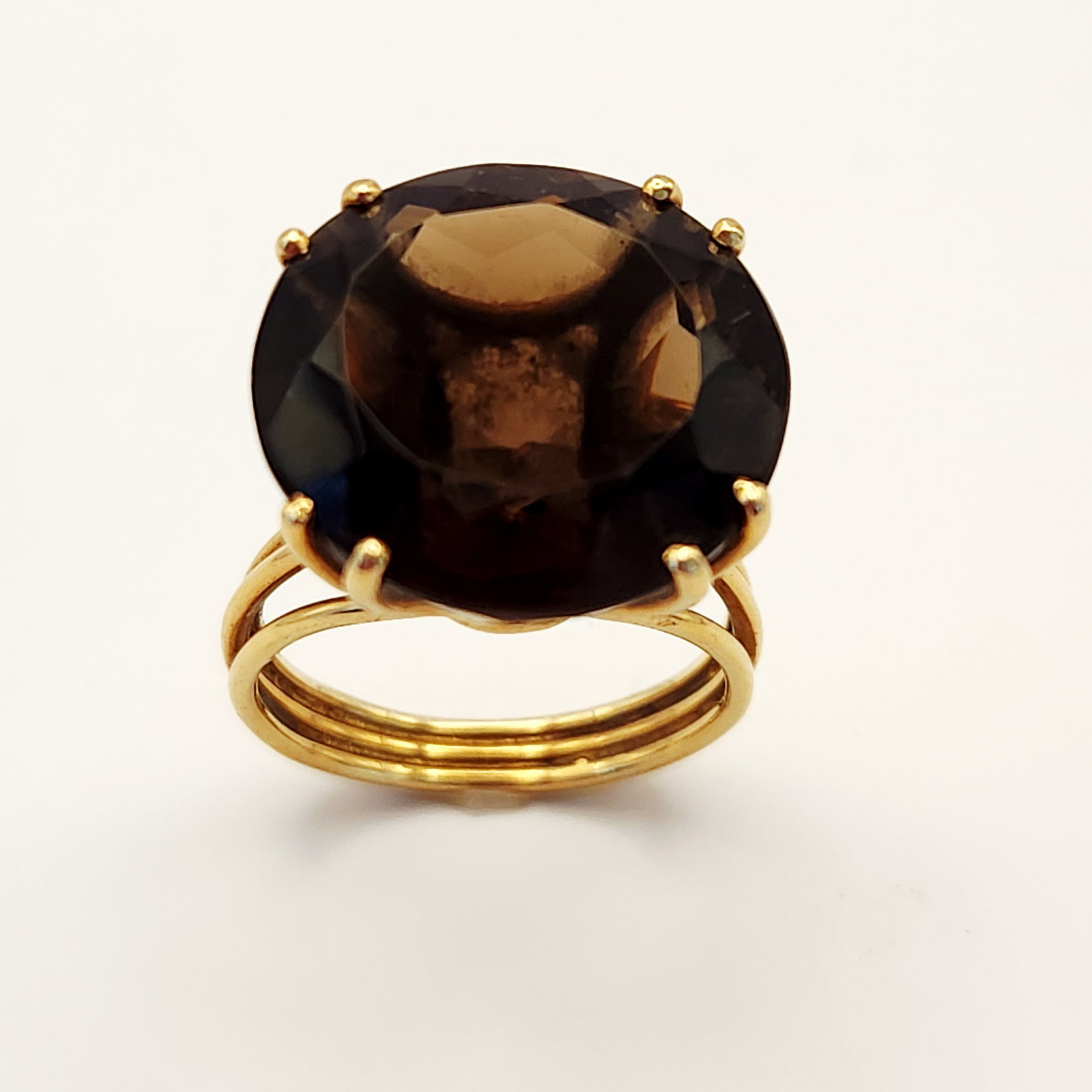 14K Gold Smoky Topaz Ring 7.7 Grams: A 14 karat yellow gold cocktail ring featuring a large, round-cut dark brown gemstone that appears to be smoky topaz. The gemstone is secured in a high-profile, multi-prong wire basket setting. The ri