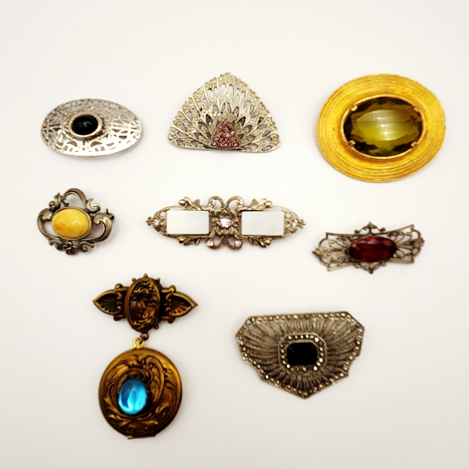 Vintage Costume & Sterling Pins 8.8 Grams: This collection consists of several vintage and costume jewelry brooches featuring various styles and materials. One prominent piece is a large oval gold-tone brooch by Accessocraft N.Y.C., featuring