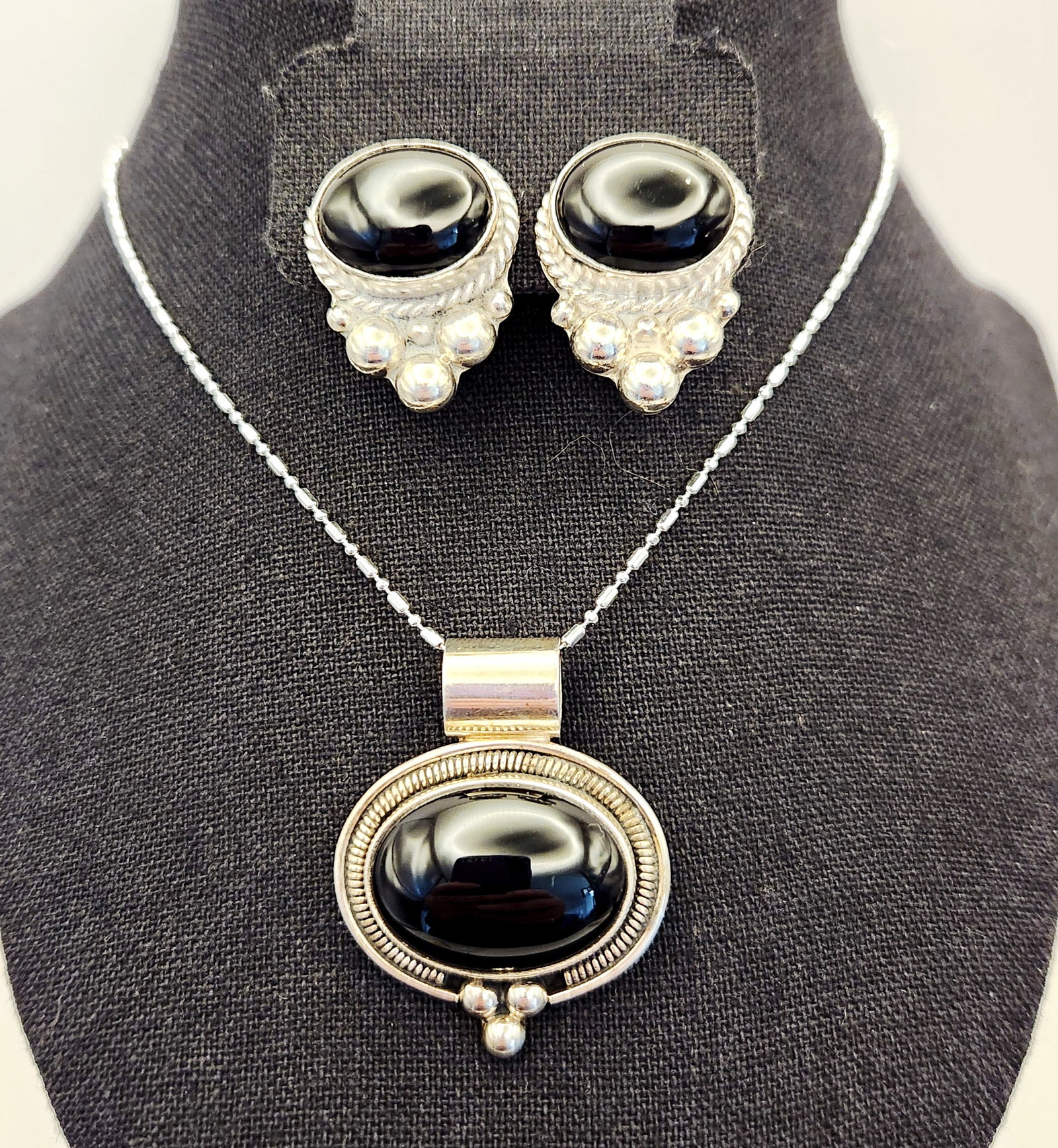 Sterling Onyx Necklace & Earrings: A sterling silver jewelry set featuring a pendant necklace and matching clip-on earrings with oval onyx marked Mexico 925 TV-M1, weighing 42.1 grams total with the pendant measuring approximately 1.5