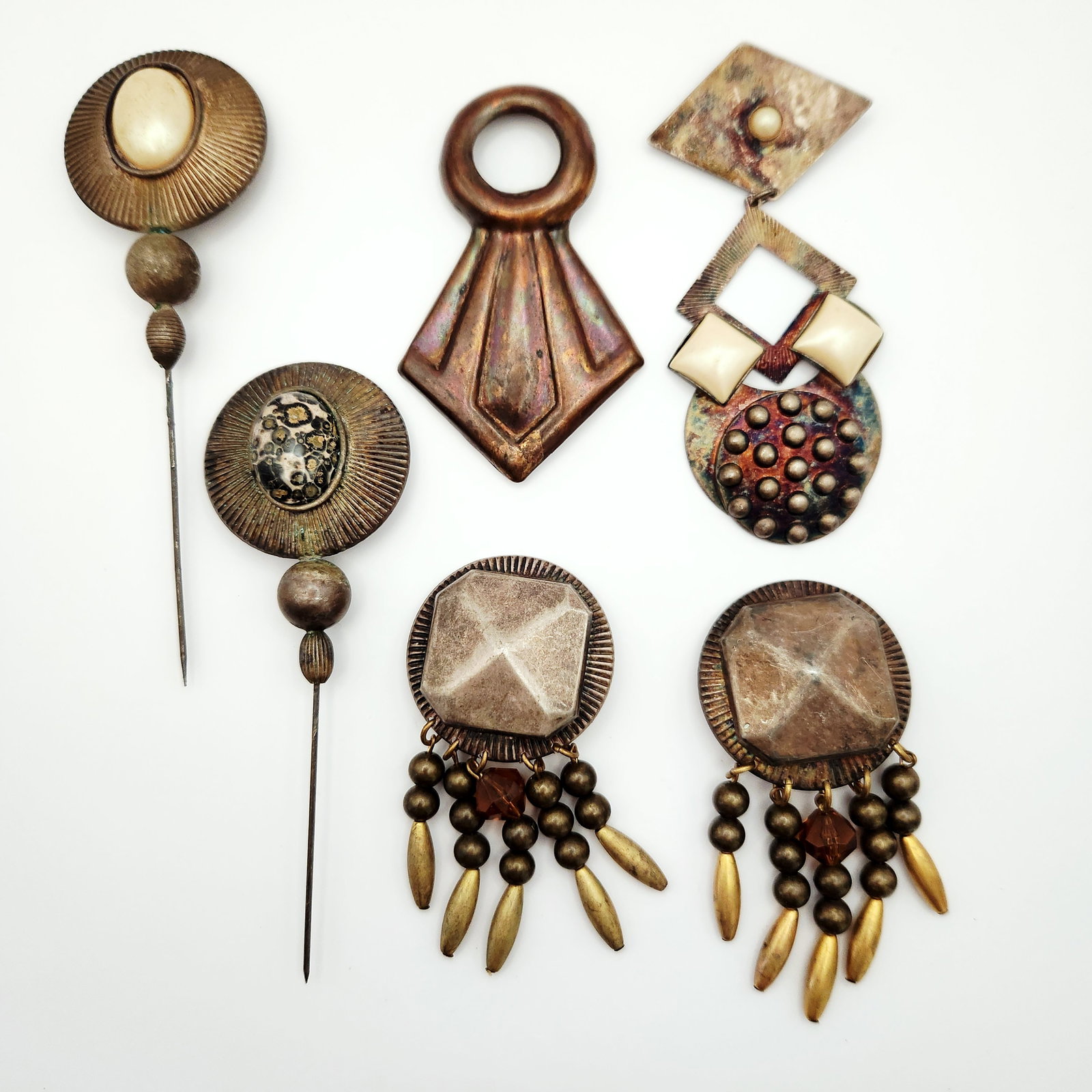 Kate Hines Modernist Costume Jewelry Pieces: This collection of six pieces of designer costume jewelry is by American designer Kate Hines. The group includes one large articulated brooch, one geometric dress clip, a pair of dangle clip-on earrin