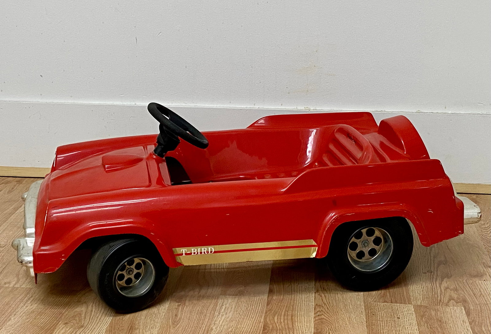 Kingsbury Toys 1986 Ford Thunderbird Style Pedal Car: This childrenâ€™s pedal car was manufactured by Kingsbury Toys and is dated 1986. The vehicle is modeled after a first-generation Ford Thunderbird. The body is constructed of red molded plasti