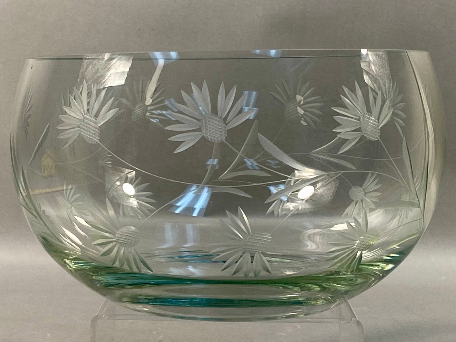 Mid-20th Century Wheel-Cut Glass Bowl with Floral Decoration: This clear glass bowl features a wheel-cut floral motif across the exterior surface. The pattern includes stylized flowers with cross-hatched centers and pointed petals, joined by trailing stems and t