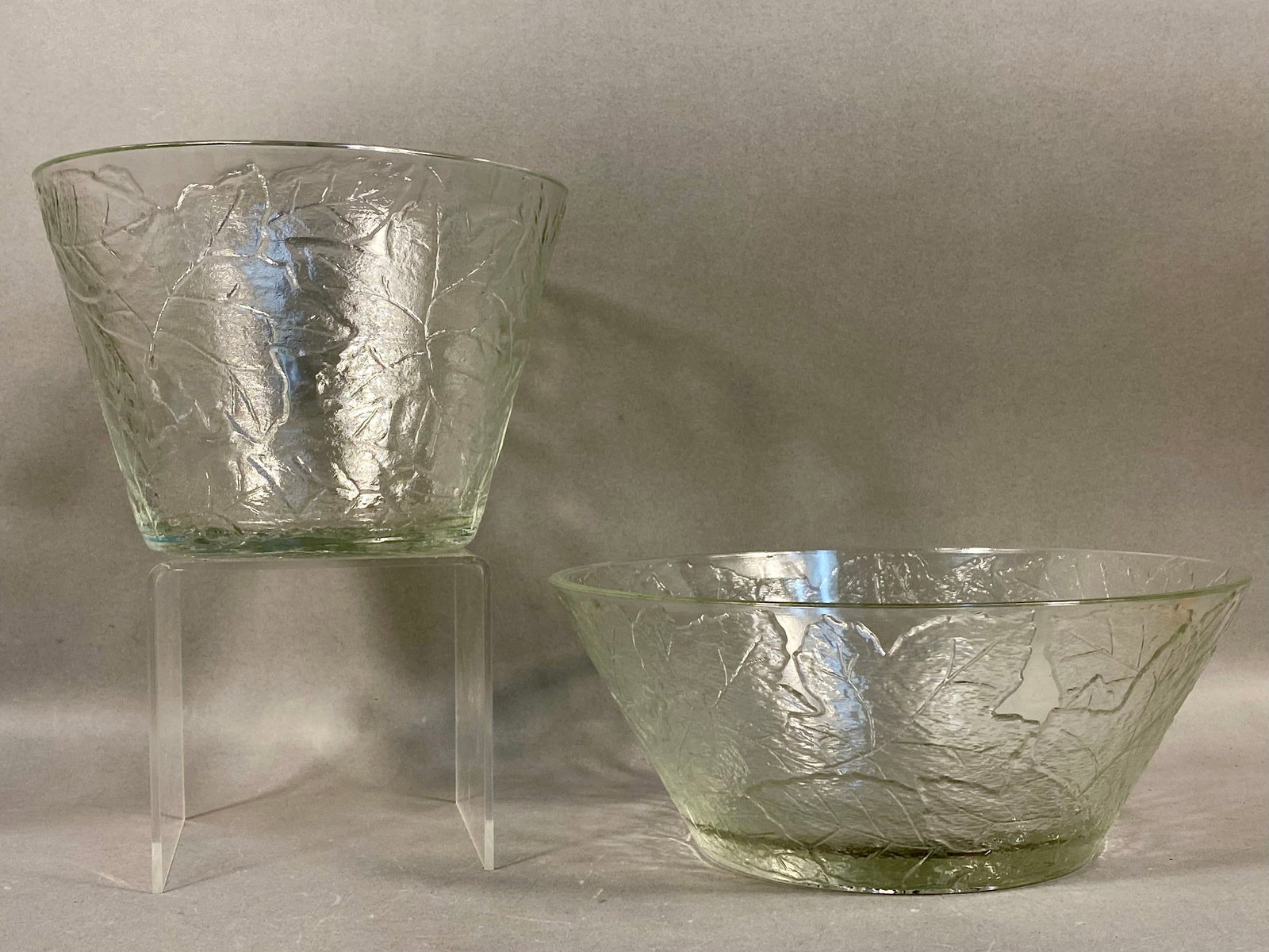 A Pair of Tiara Exclusives Clear Pressed Glass Serving Pieces: This pair of clear pressed glass serving pieces featuring an all-over relief pattern of overlapping leaves, resembling maple or oak, set against a heavily textured background and was produced for Tiar