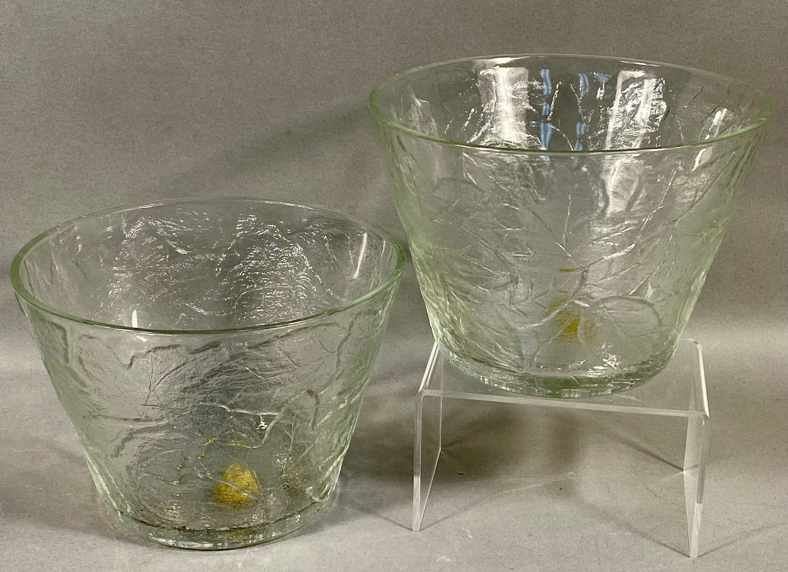 A Pair of Tiara Exclusives Clear Pressed Glass Chestnut Leaf Pattern Bowls: This pair of matching bowls was produced for Tiara Exclusives, an American distributor active between 1970 and 1998. The pieces are constructed of clear pressed glass in the Chestnut Leaf pattern. The