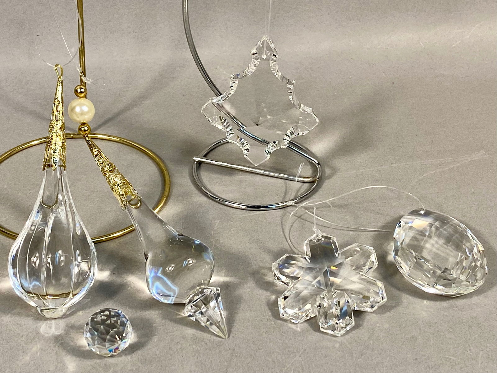 A Collection of Six Faceted Crystal and Blown Glass Suncatchers: A collection of six clear decorative ornaments or suncatchers composed of faceted crystal and blown glass. The grouping includes two teardrop ornaments featuring ornate gold-toned metal filigree caps.