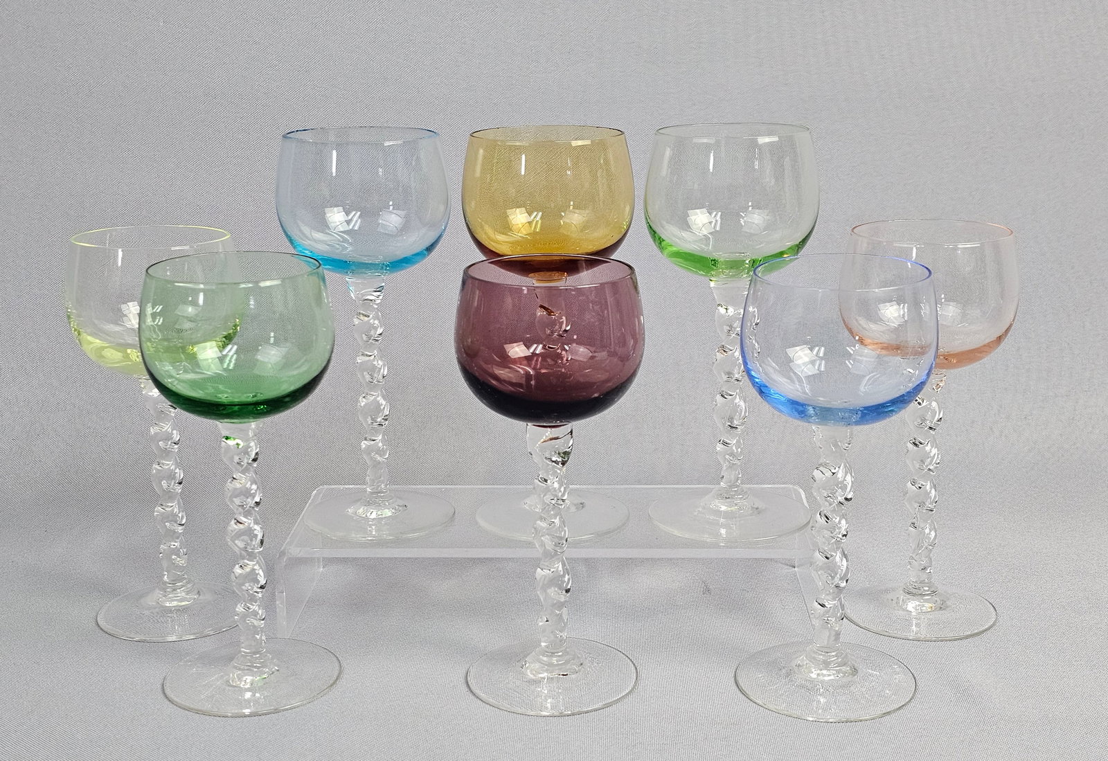 A Set of 8 Mid-Century Modern Style Multi-Colored Glass Goblets with Twisted Stems: A set of eight wine or hock-style glasses featuring multi-colored bowls and clear, hand-formed stems. Each goblet is constructed with a thin-walled, rounded bowl in a unique color, including two shade