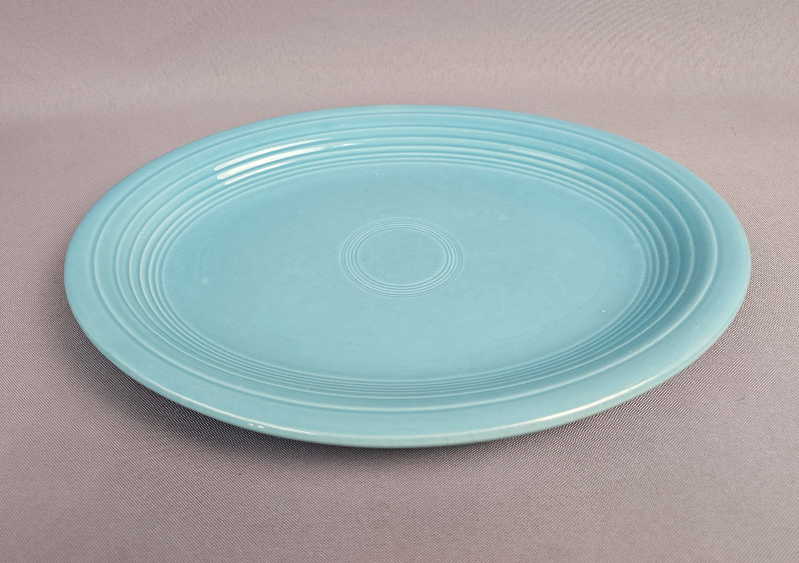 Homer Laughlin Fiesta Turquoise Oval Serving Platter: This oval serving platter is manufactured by the Homer Laughlin China Company as part of the Fiesta dinnerware line. The piece is constructed from semi-vitreous earthenware and finished in a solid tur