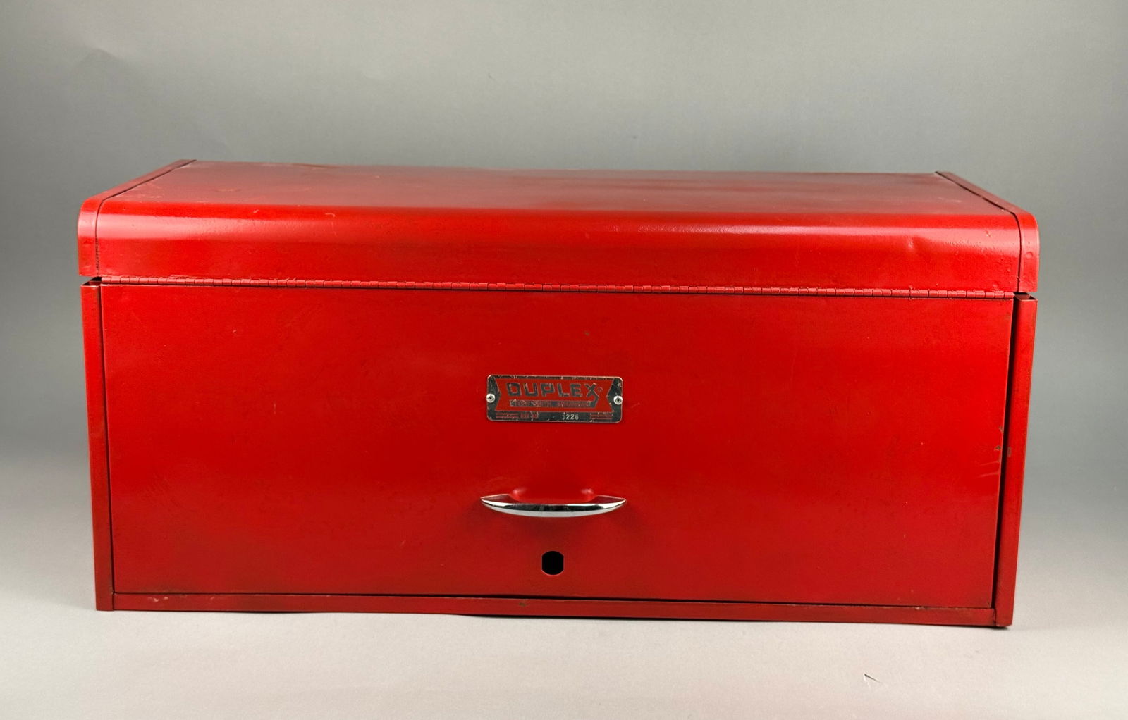 Duplex Model 1226 Metal Toolbox: A Duplex brand metal toolbox, model number 1226, manufactured in Fort Smith, Arkansas. The piece features a red painted exterior with a hinged top lid and a drop-down front panel. The interior configu