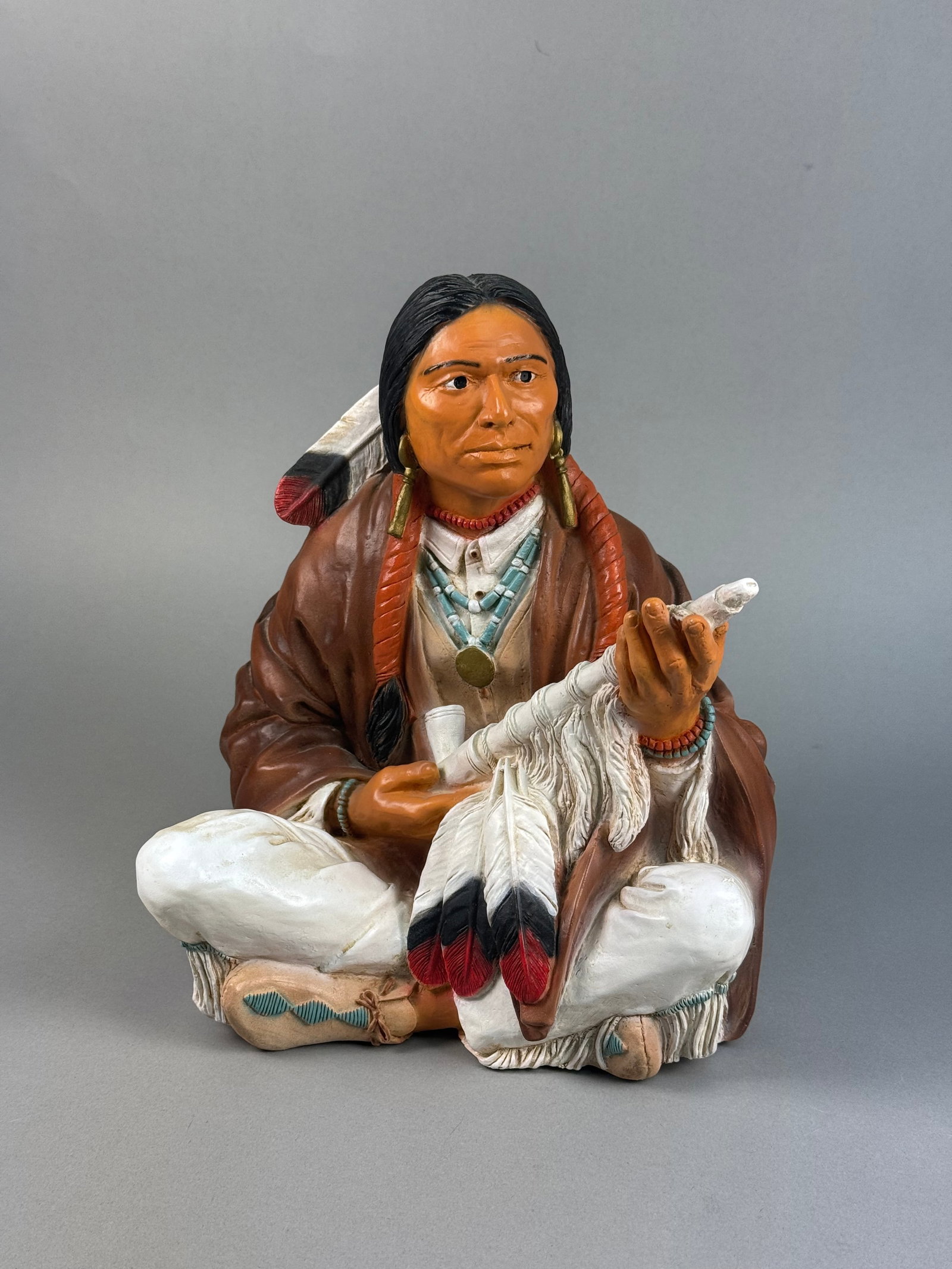 Castagna Infrangible Line Seated Native American Figurine 1994: A hand-painted figurine of a seated Native American man produced by Castagna as part of the Infrangible Line. The piece is made of a proprietary resin or composite material designed for break resistan