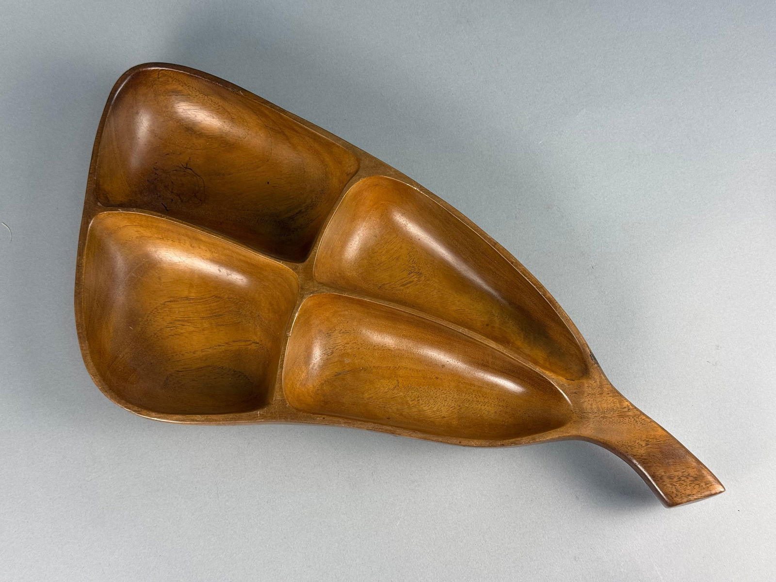 Mid-Century Modern Monkey Pod Wood Leaf-Shaped Divided Serving Tray: A mid-century modern four-compartment serving tray hand-carved from a single block of hardwood, identified by web consensus as monkey pod wood. The tray is carved in an organic, stylized leaf shape fe