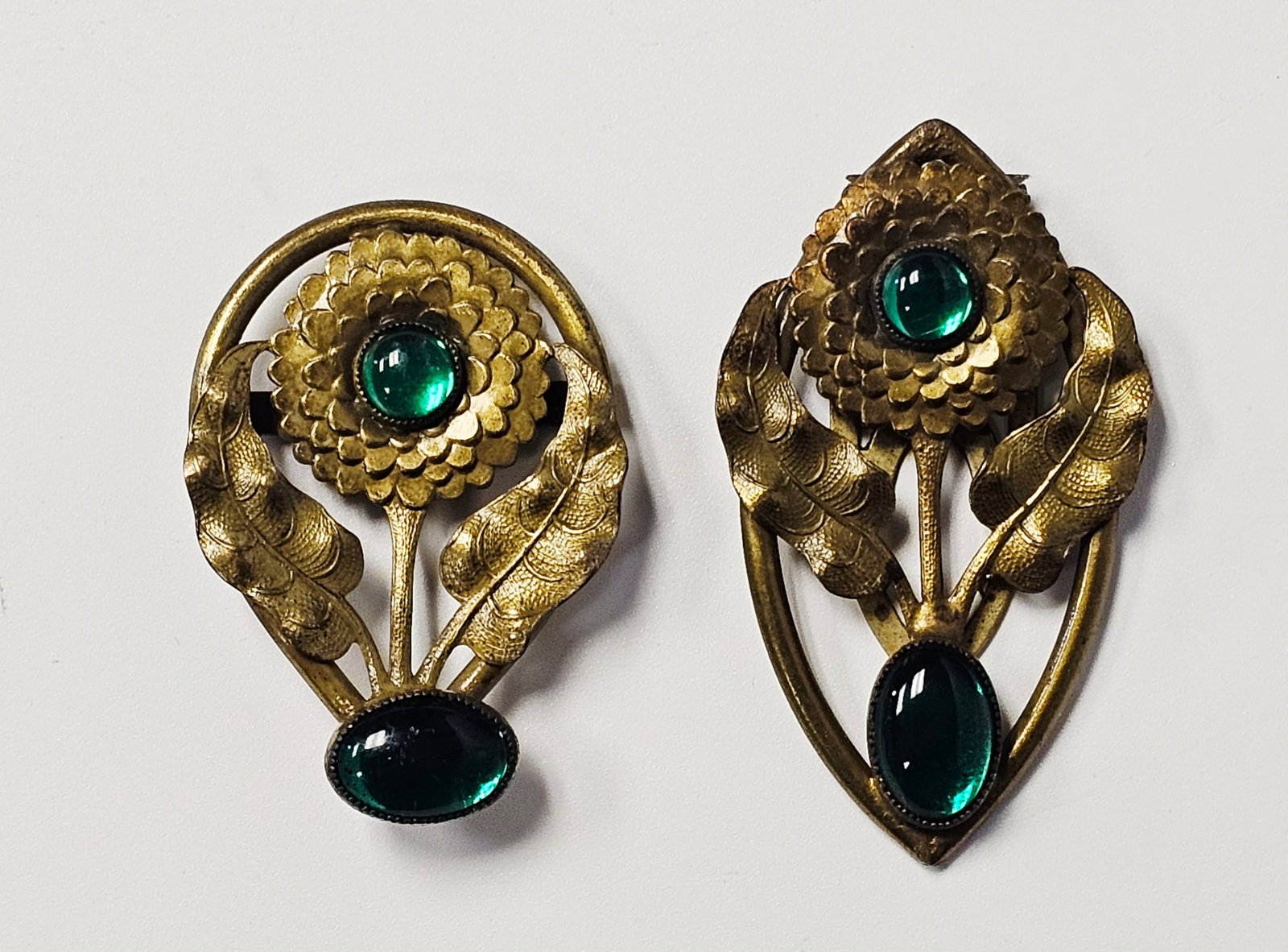 Vintage Gold-Tone Green Glass Fur Clip & Belt Buckle: Each is constructed from gold-tone base metal with a matte and brushed finish and textured detailing. The design consists of a central multi-petaled flower head flanked by two veined leaves. Each is