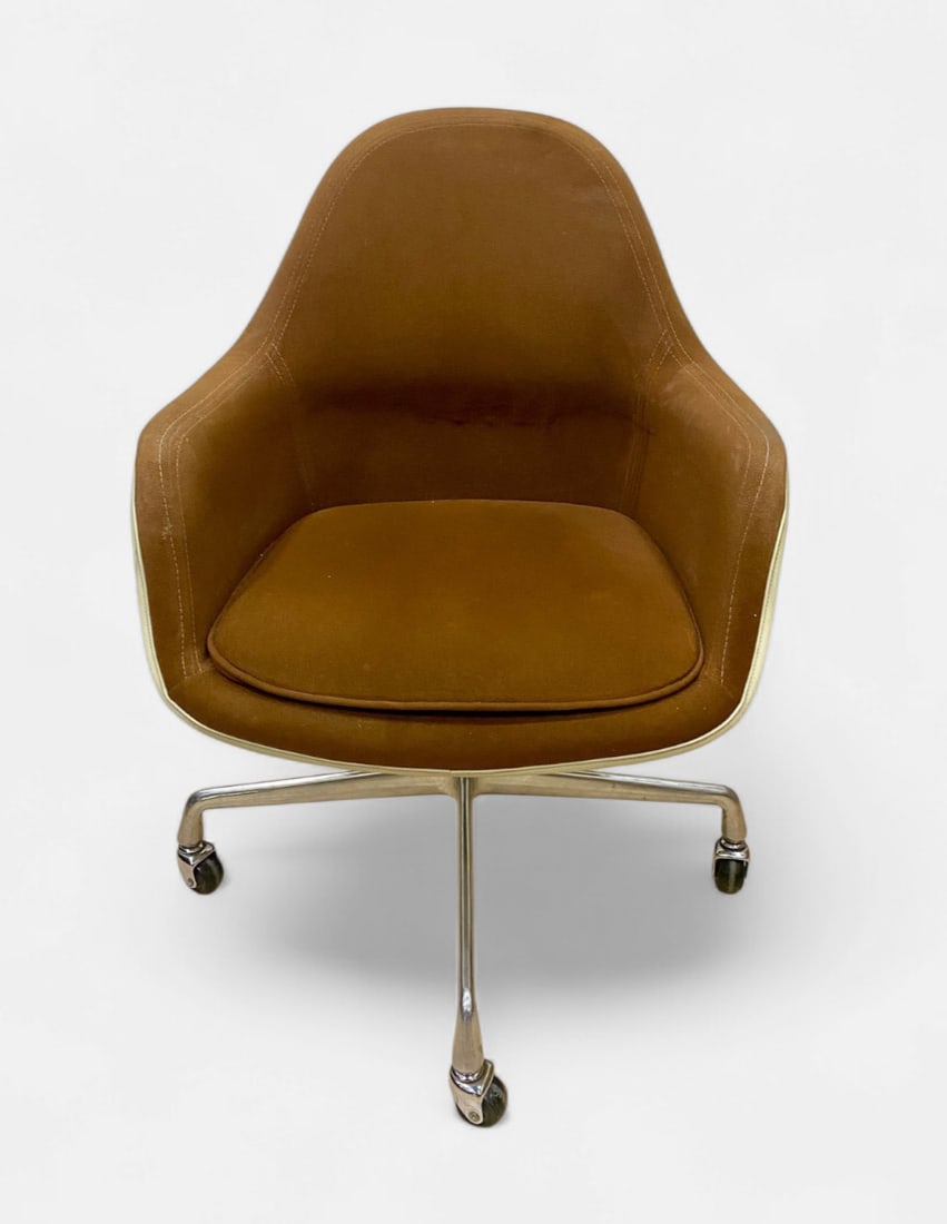 Herman Miller Charles Eames Loose Cushion Fiberglass Shell Armchair: A Herman Miller loose cushion armchair designed by Charles and Ray Eames. This professional office chair features a molded parchment-colored fiberglass shell with an integrated upholstered interior in