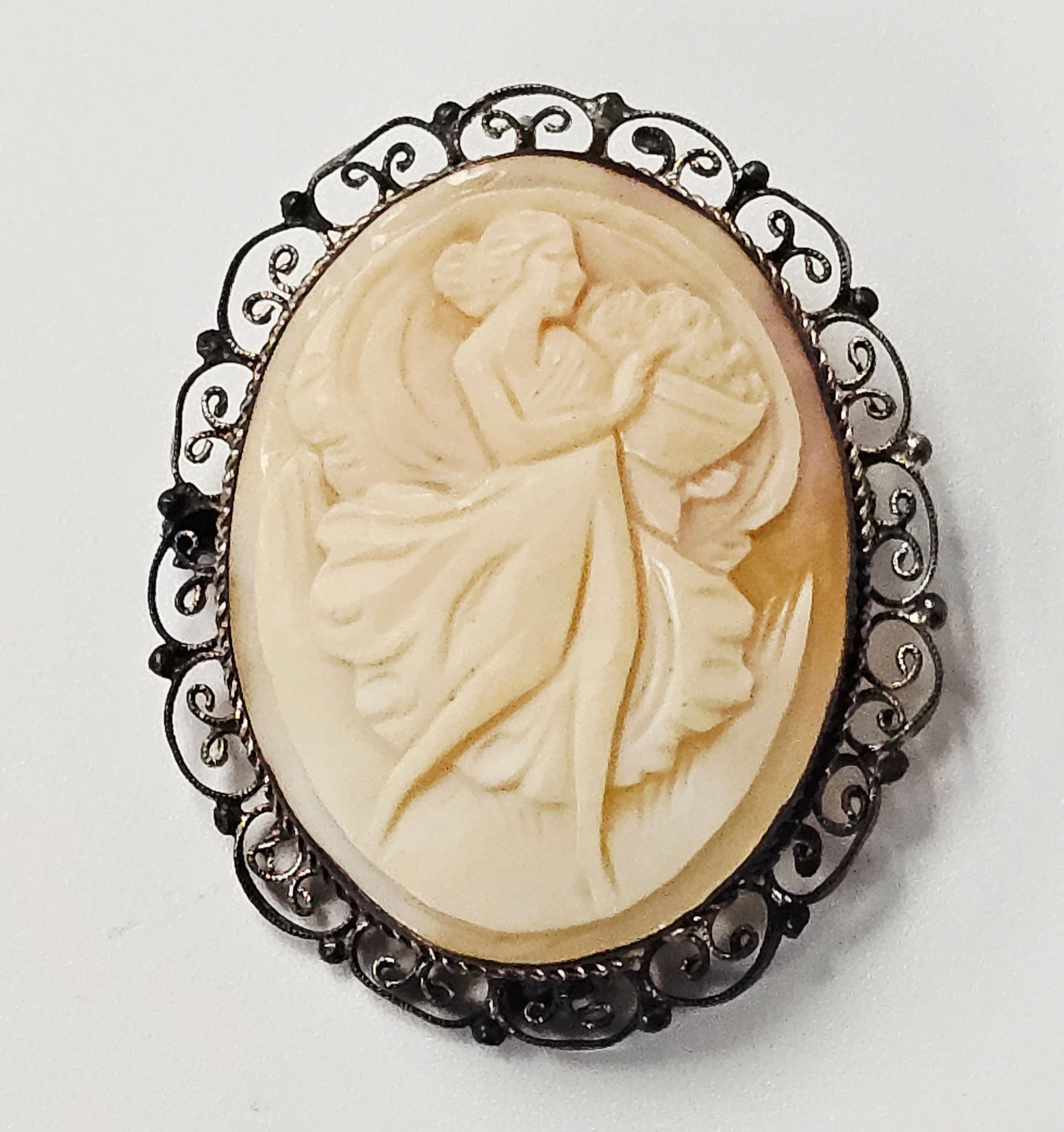 Italian 800 Silver Filigree Carved Shell Cameo Brooch 7.5 Grams: An oval shell cameo featuring a carved classical-style female figure in profile. The figure is shown wearing a flowing gown and carrying a cornucopia or basket of flowers. The carving consists of a cr