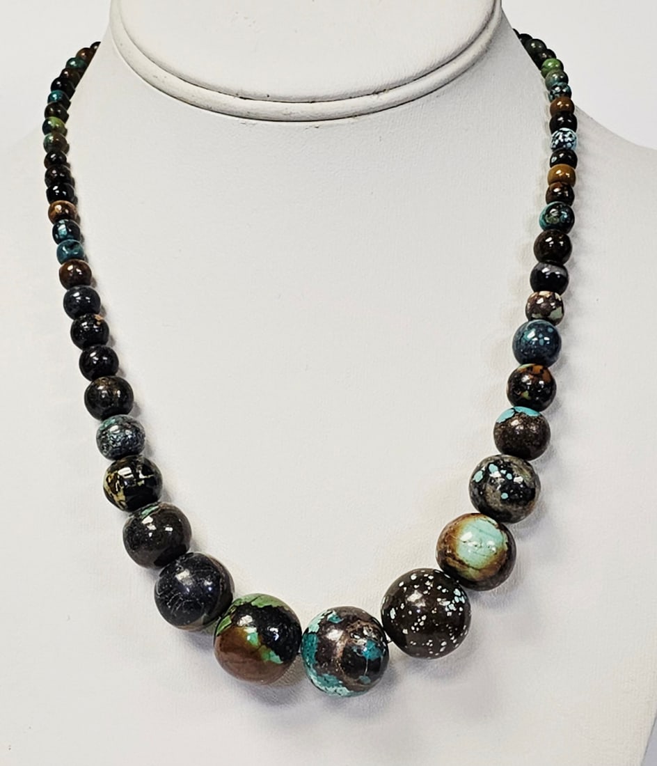 Jay King Sterling Graduated Boulder Turquoise Bead Necklace: This graduated bead necklace is composed of round, polished stones featuring a dark matrix with vibrant turquoise-blue, green, and tan inclusions, which appear to be boulder turquoise. The beads are a