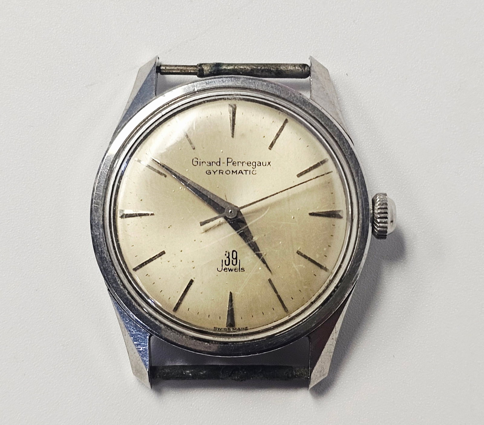 Girard-Perregaux Gyromatic 39 Jewels Stainless Steel Wristwatch: A vintage Girard-Perregaux Gyromatic wristwatch featuring an automatic movement. The watch is constructed with a stainless steel case and a screw-down case back. The dial is a patinated champagne or s