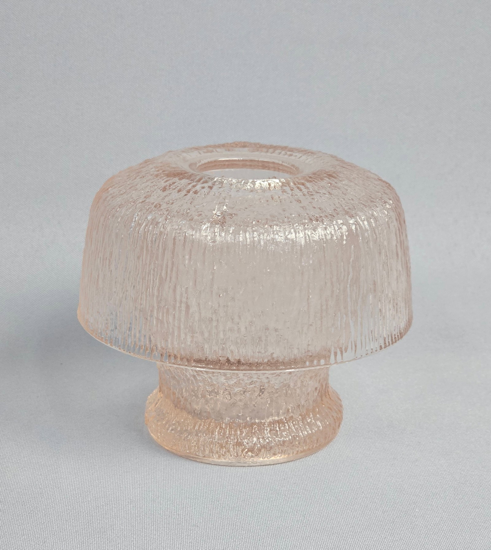Mid-Century Modern Pink Textured Glass Mushroom Fairy Lamp: A two-piece mid-century modern mushroom-shaped candle holder, also known as a fairy lamp, crafted in pale pink art glass. The item consists of a domed shade and a pedestal base, both featuring a