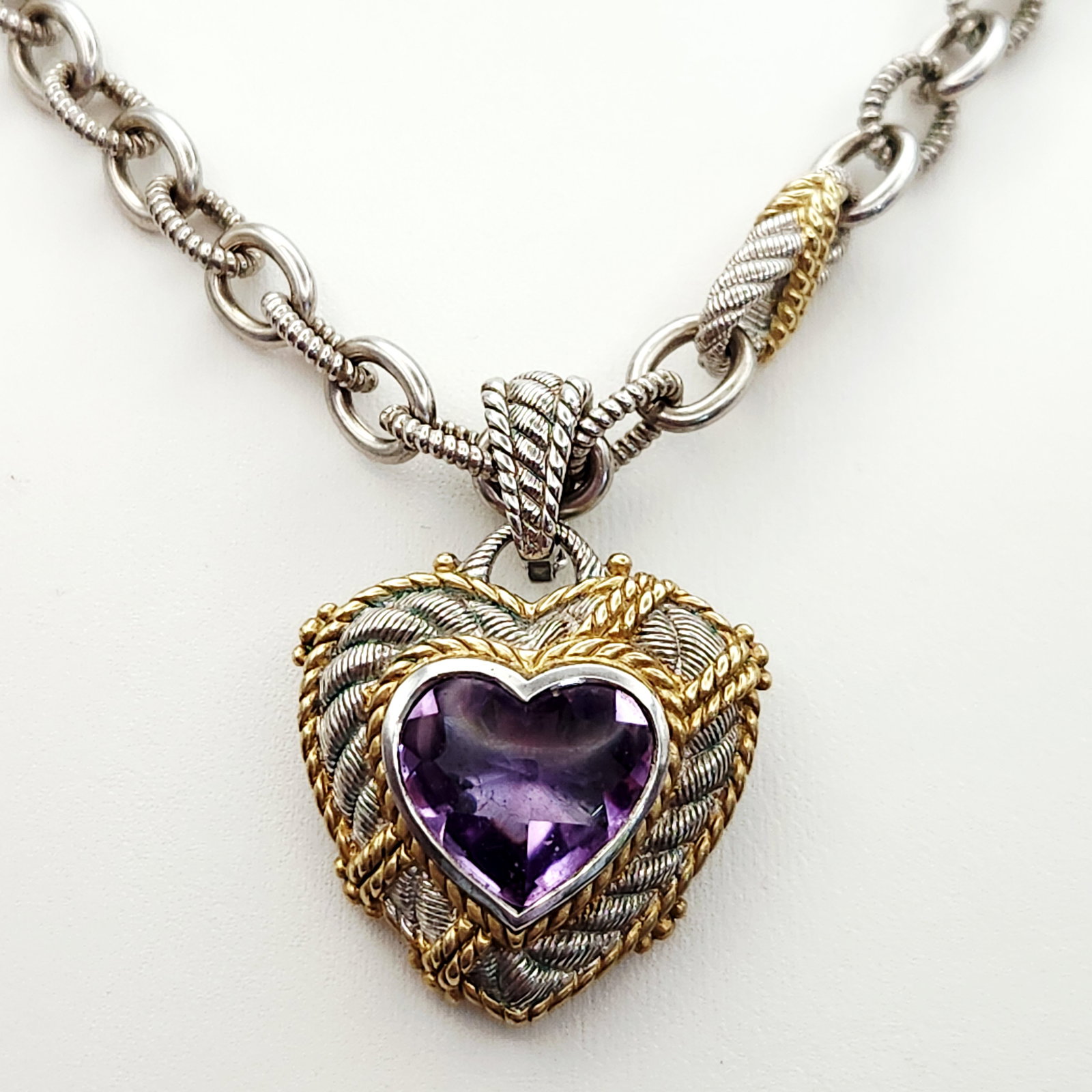 Judith Ripka Sterling & Vermeil Necklace 74.3 Grams: A Judith Ripka sterling silver and gold-tone heart pendant necklace featuring a faceted purple cz with a branded jewelry pouch. Necklace 74.3 grams & is 18". Necklace is in very good conditi