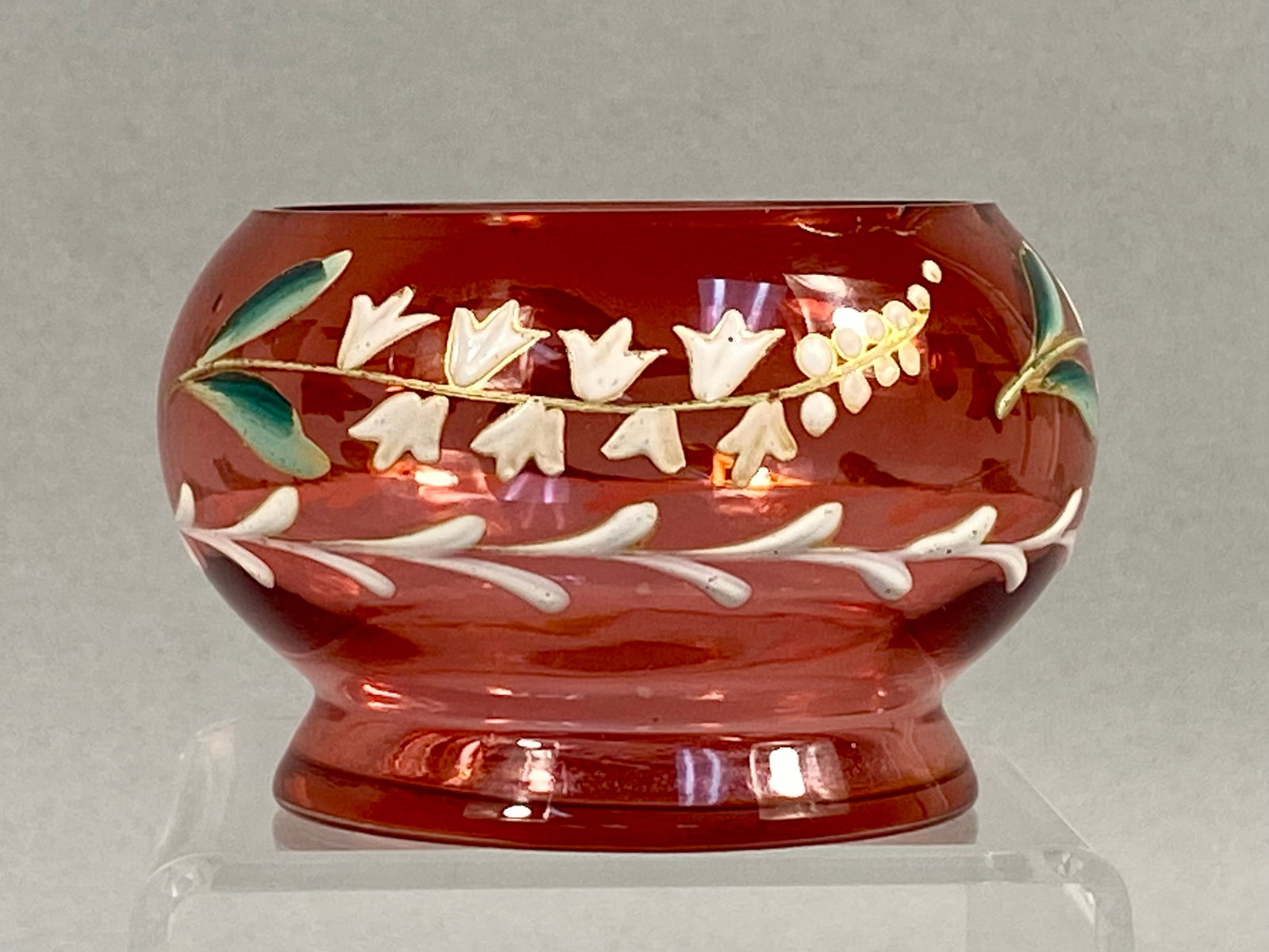 Late Victorian Enameled Cranberry Glass Miniature Bowl: A hand-blown cranberry glass miniature bowl or open salt cellar, dating to approximately 1890. The vessel is crafted from deep red glass in a bulbous form that tapers to a short, flared foot. The exte