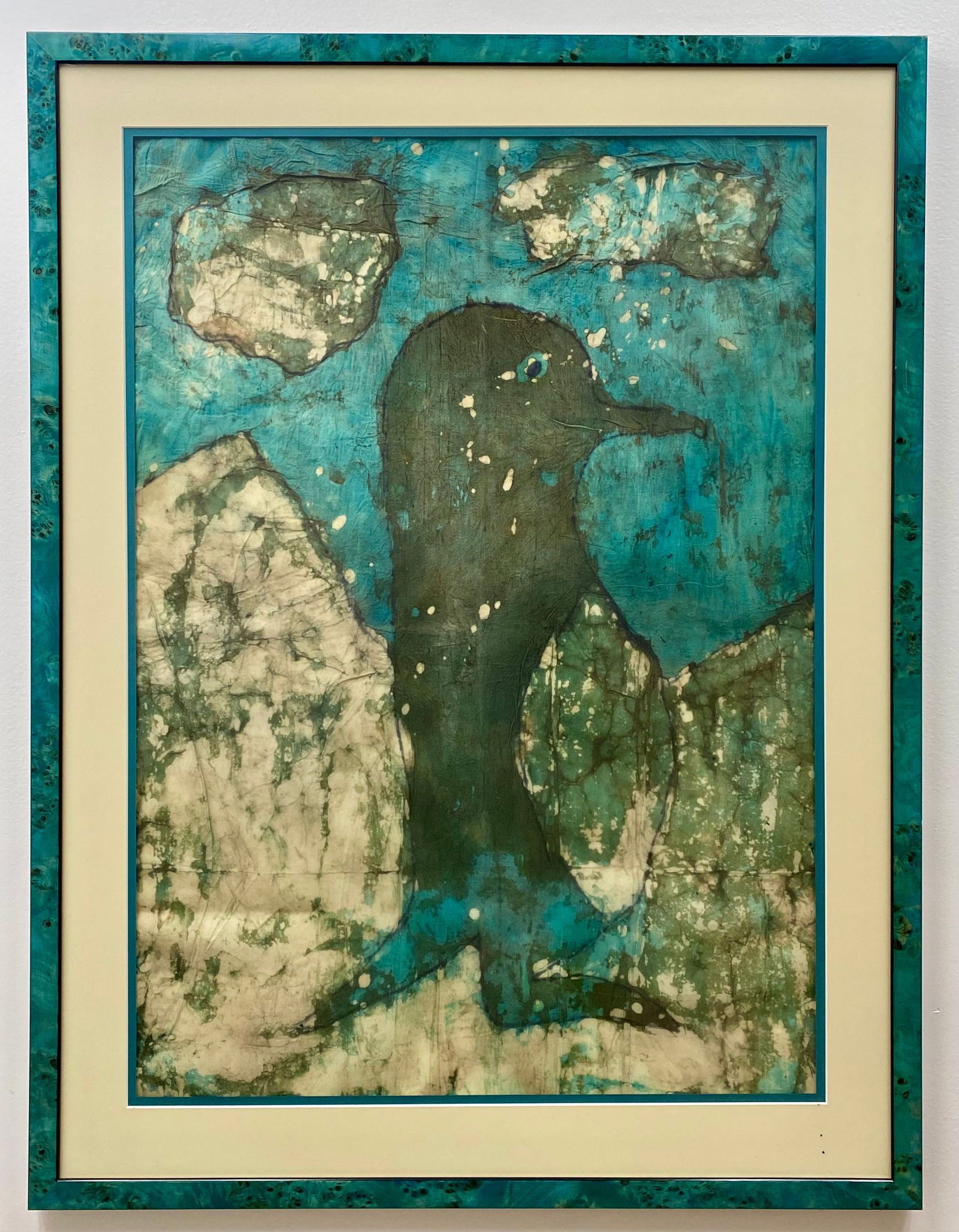 Contemporary Batik Textile Art Depicting a Penguin: This contemporary batik textile artwork depicts a stylized penguin set against a landscape of rocky or icy formations under a vibrant turquoise sky with floating clouds. The piece is executed using wa