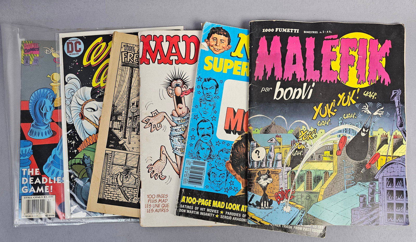 An Assortment of Comic Books and Magazines Including Wonder Woman, Mad, and Aladdin (1 of 20)