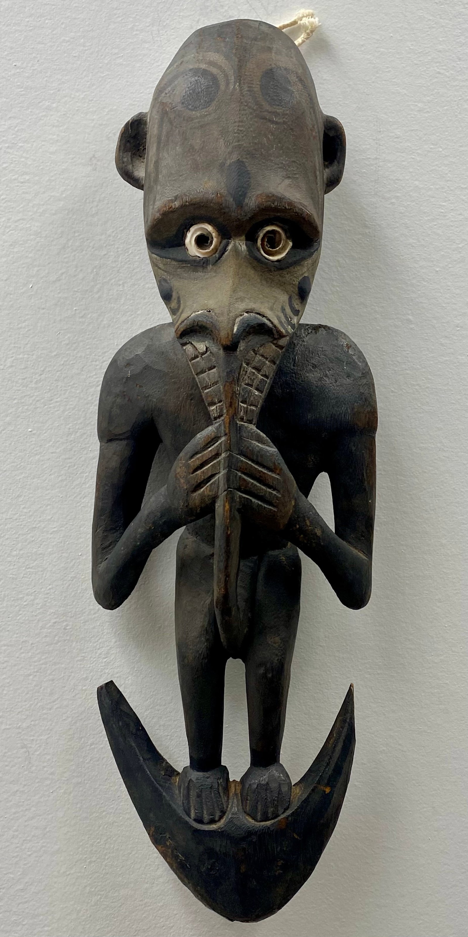 Papua New Guinea Sepik River Carved Wood Spirit Figure Suspension Hook: This is a hand-carved hardwood spirit figure from the Sepik River region of Papua New Guinea. The anthropomorphic figure is designed as a suspension hook, a form traditionally used in communal longhou