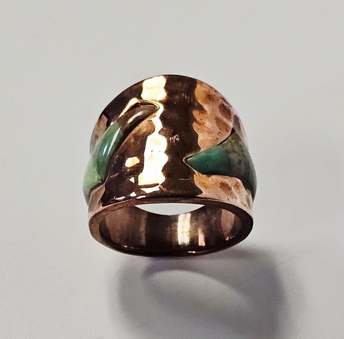 Jay King Hammered Copper Turquoise Wide Band Ring: This wide band statement ring is crafted from copper metal with a textured, hammered finish. The exterior features two sections of inlaid turquoise stones in curved, pointed shapes. Weight: 10.2 grams