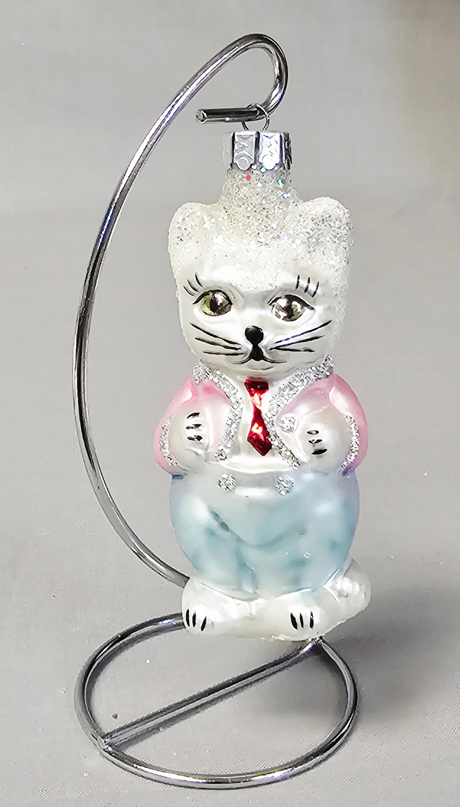 Christopher Radko Glass Cats & Kittens Ornament: Stand not included. This hand-blown glass Christmas ornament depicts an anthropomorphic white cat standing upright. The ornament is in good condition with minor, age-appropriate glitter loss on the te