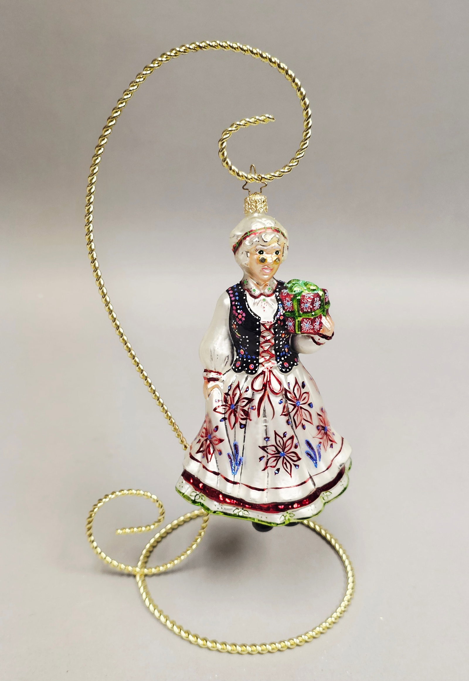 Christopher Radko Festive Folk Mrs Claus Ornament: Stand not included. This hand-blown glass Christmas ornament depicts a female figure in traditional European folk attire, closely resembling Polish folk costumes. The ornament is in excellent conditio