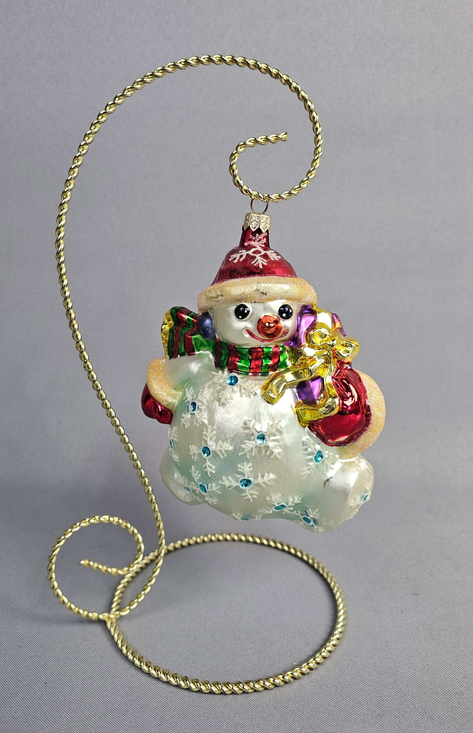 Christopher Radko Glass Snowman Holiday Ornament: Stand not included. Attributed to the Christopher Radko Company, this hand-blown glass Christmas ornament depicts a whimsical snowman figure. The ornament is in very good overall condition. A small da