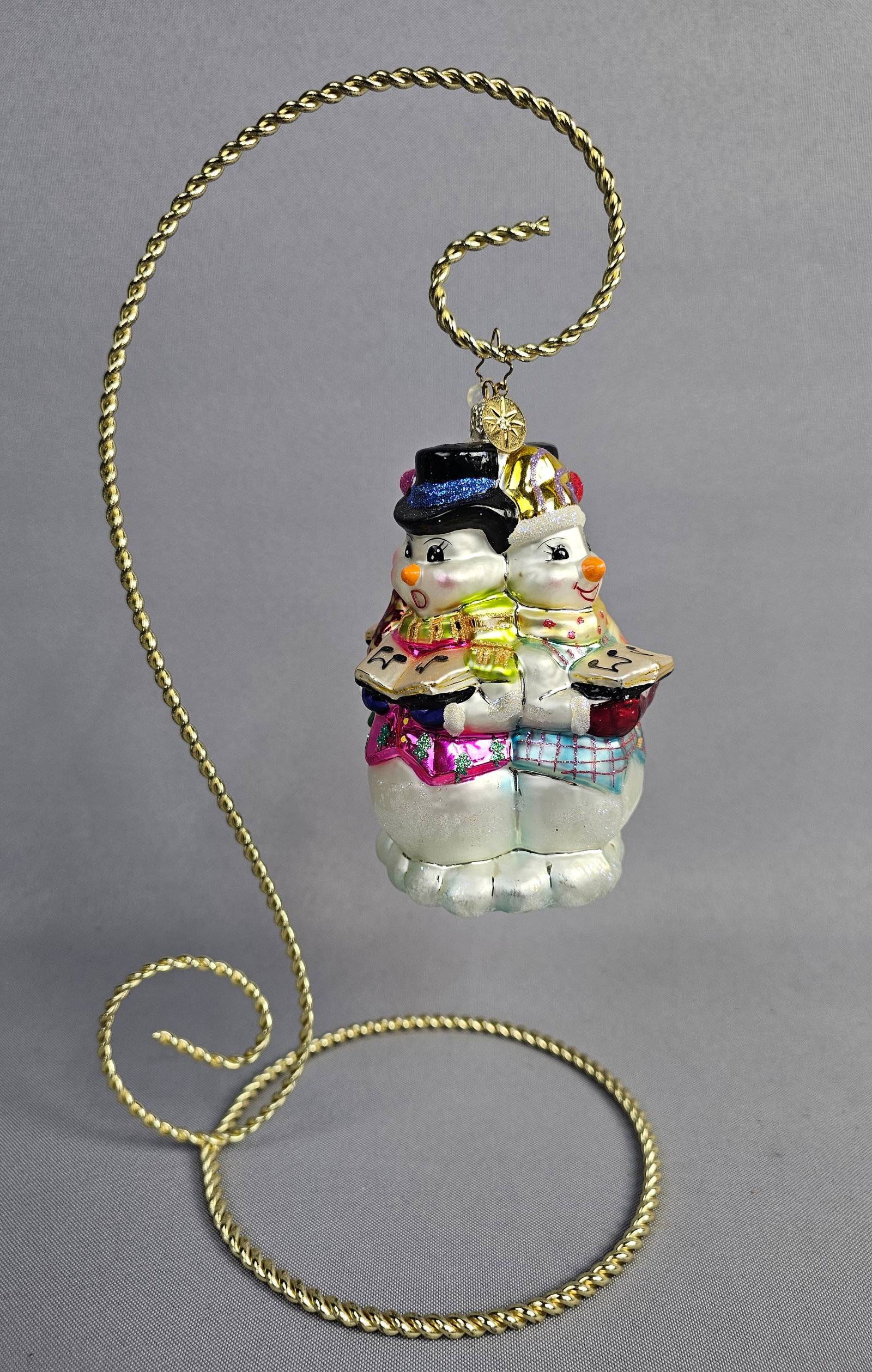 Christopher Radko Glass Trio of Singing Snowman Ornament: Stand not included. This hand-blown glass Christmas ornament, produced by Christopher Radko, depicts a trio of snowman carolers. The ornament is in excellent condition with no visible chips, cracks, o
