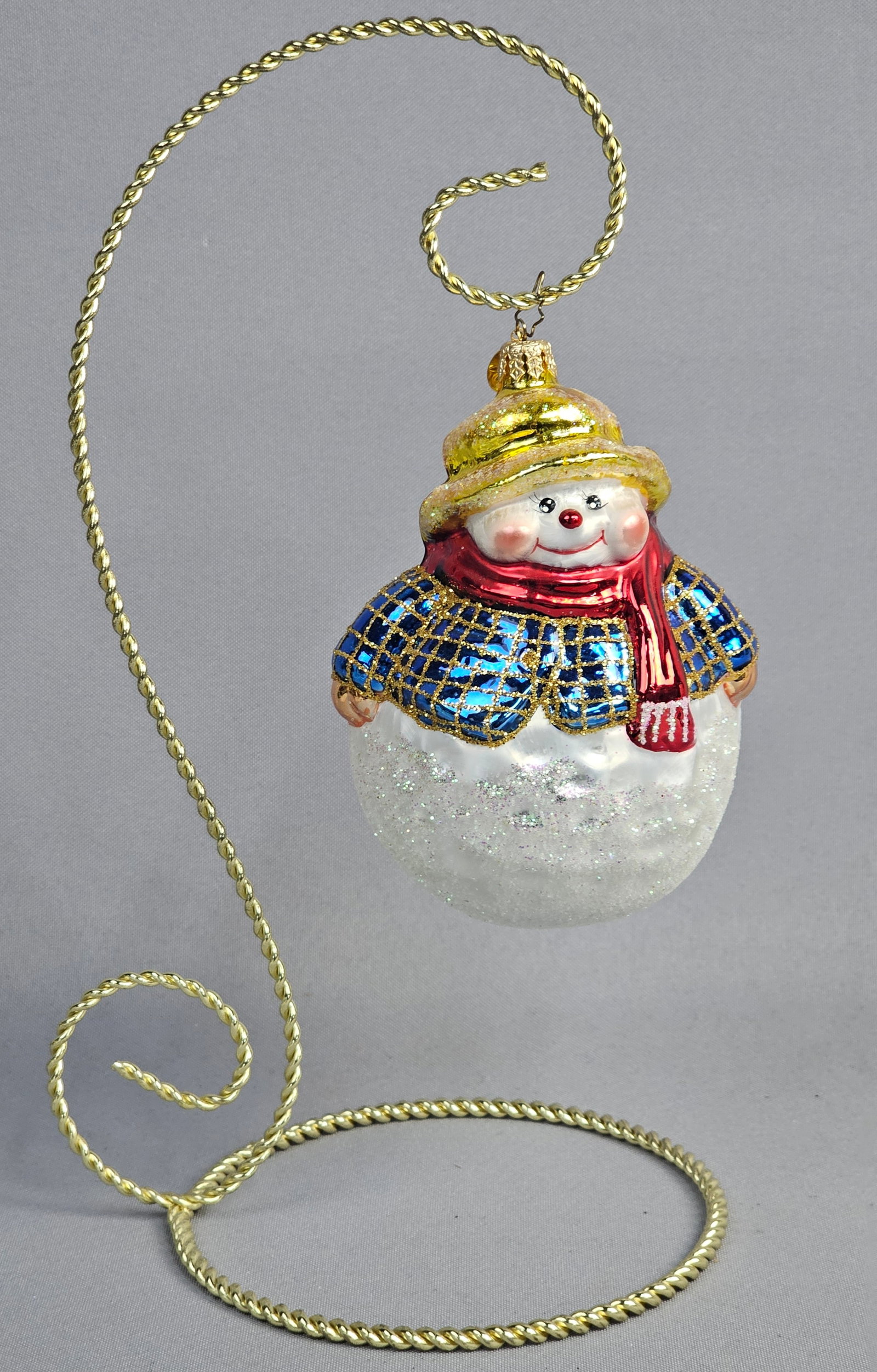 Christopher Radko Hand-Crafted Glass Snowman Ornament: Stand not included. This is a hand-crafted glass Christmas ornament from Christopher Radko, identified by the signature gold-toned eight-pointed star charm attached to the hanging loop. The ornament d
