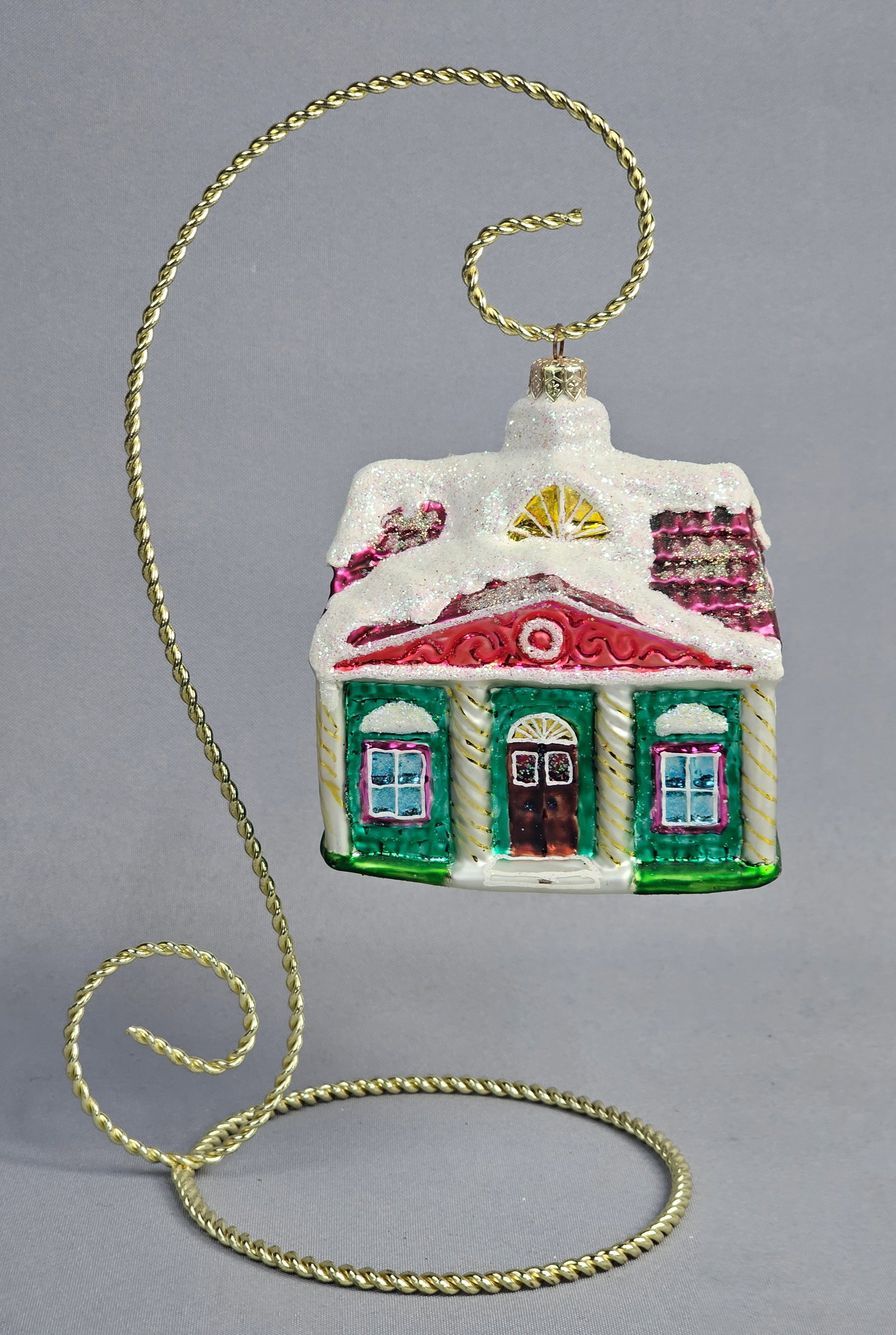 Christopher Radko Christmastime Cottage Blown Glass Christmas Ornament: A hand-blown glass Christmas ornament produced by Christopher Radko, identified as the Christmastime Cottage pattern. The ornament is fashioned in the form of a festive manor with emerald-green walls,