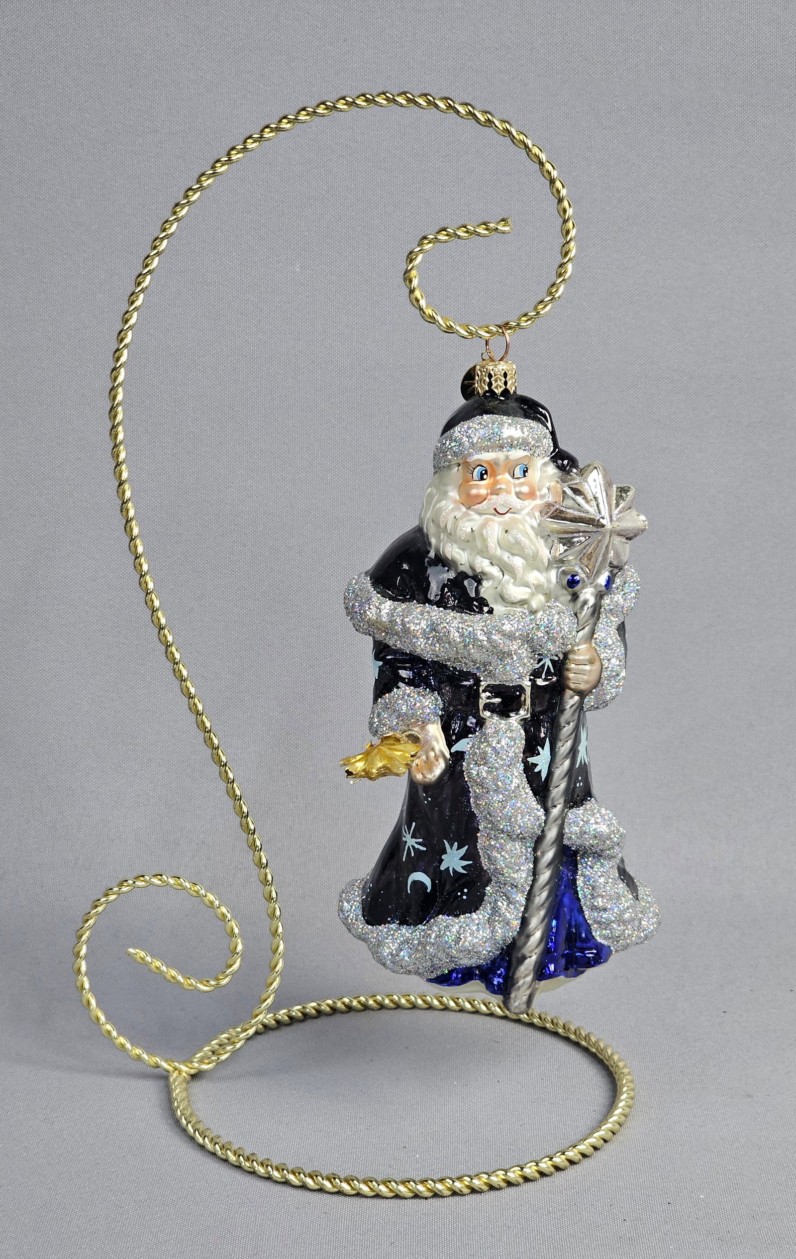 Christopher Radko for Roger's Gardens Blown Glass Celestial Santa Ornament: This hand-blown and hand-painted glass Christmas ornament depicts a celestial-themed Santa Claus, produced by Christopher Radko for the retailer Roger's Gardens. The figure is dressed in a deep midnig