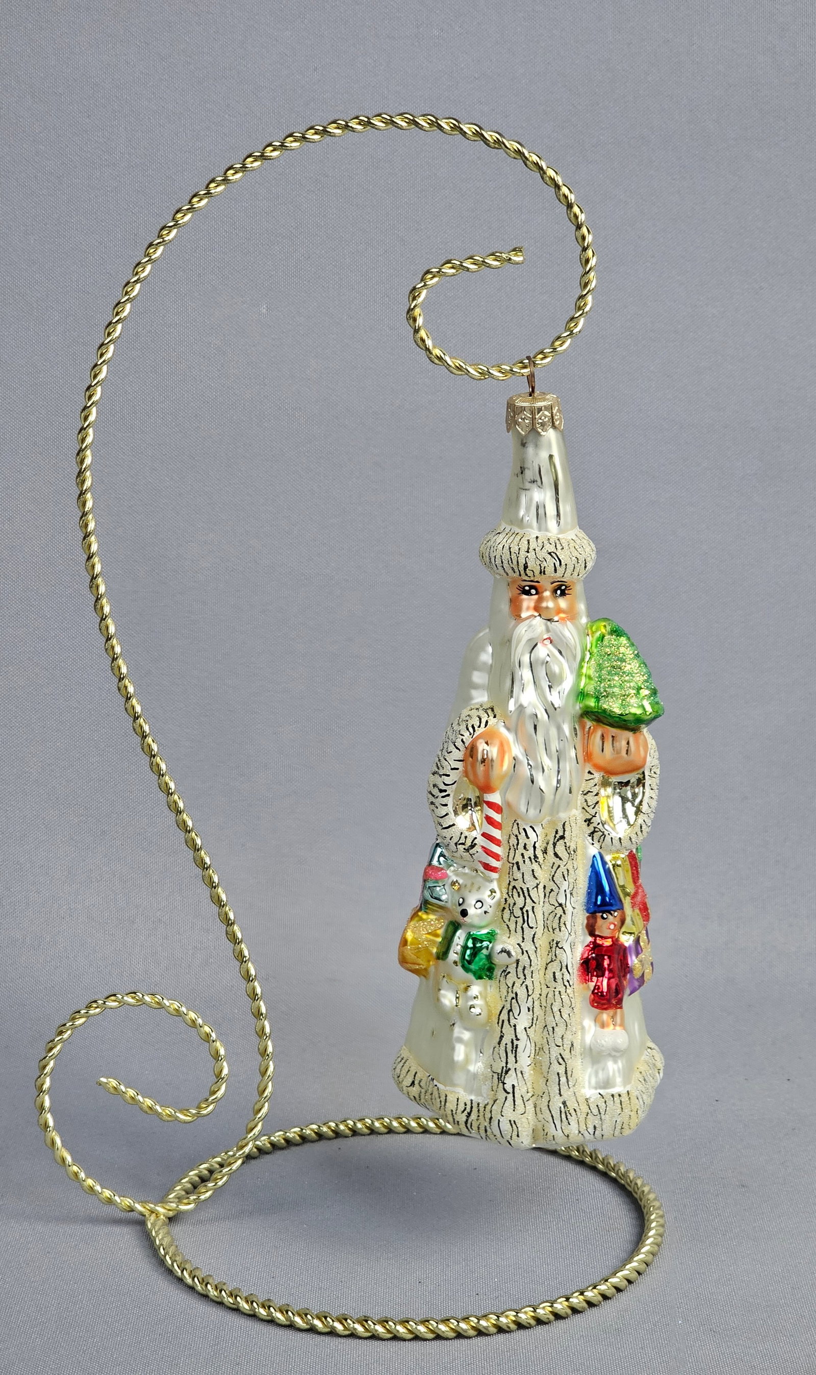 Christopher Radko Hand-Blown Glass Santa Claus Christmas Ornament: A hand-blown glass Christmas ornament by Christopher Radko depicting a tall, slender Santa Claus figure. The figure is clad in a long, pearlescent white robe and matching tall, tapered hat, both finis