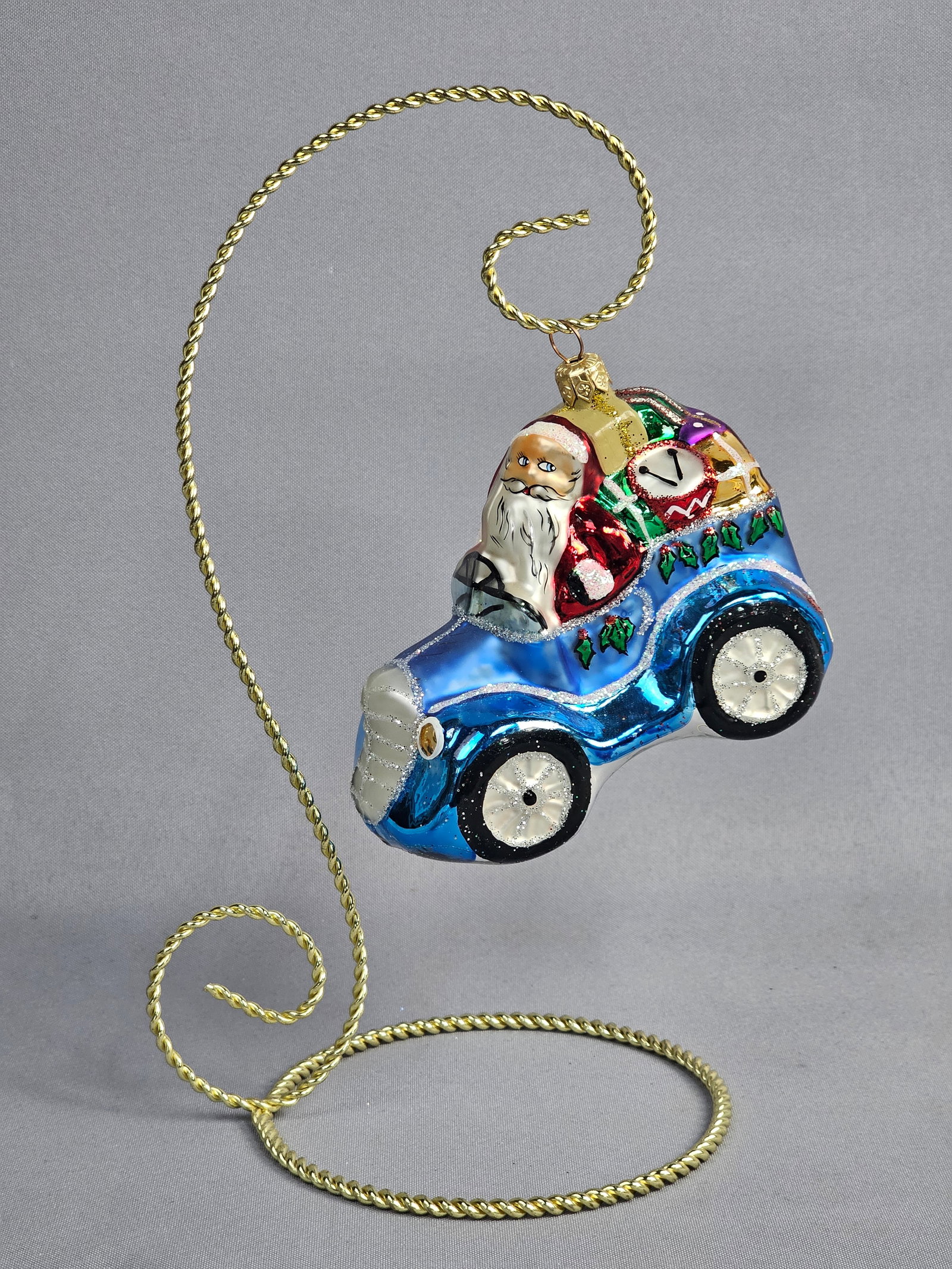 Christopher Radko Jolly Jalopy 1997 Hand-Blown Glass Christmas Ornament: A 1997 Christopher Radko Jolly Jalopy hand-blown glass Christmas ornament. The piece depicts Santa Claus in a traditional red suit driving a cobalt blue vintage-style convertible automobile. The vehic