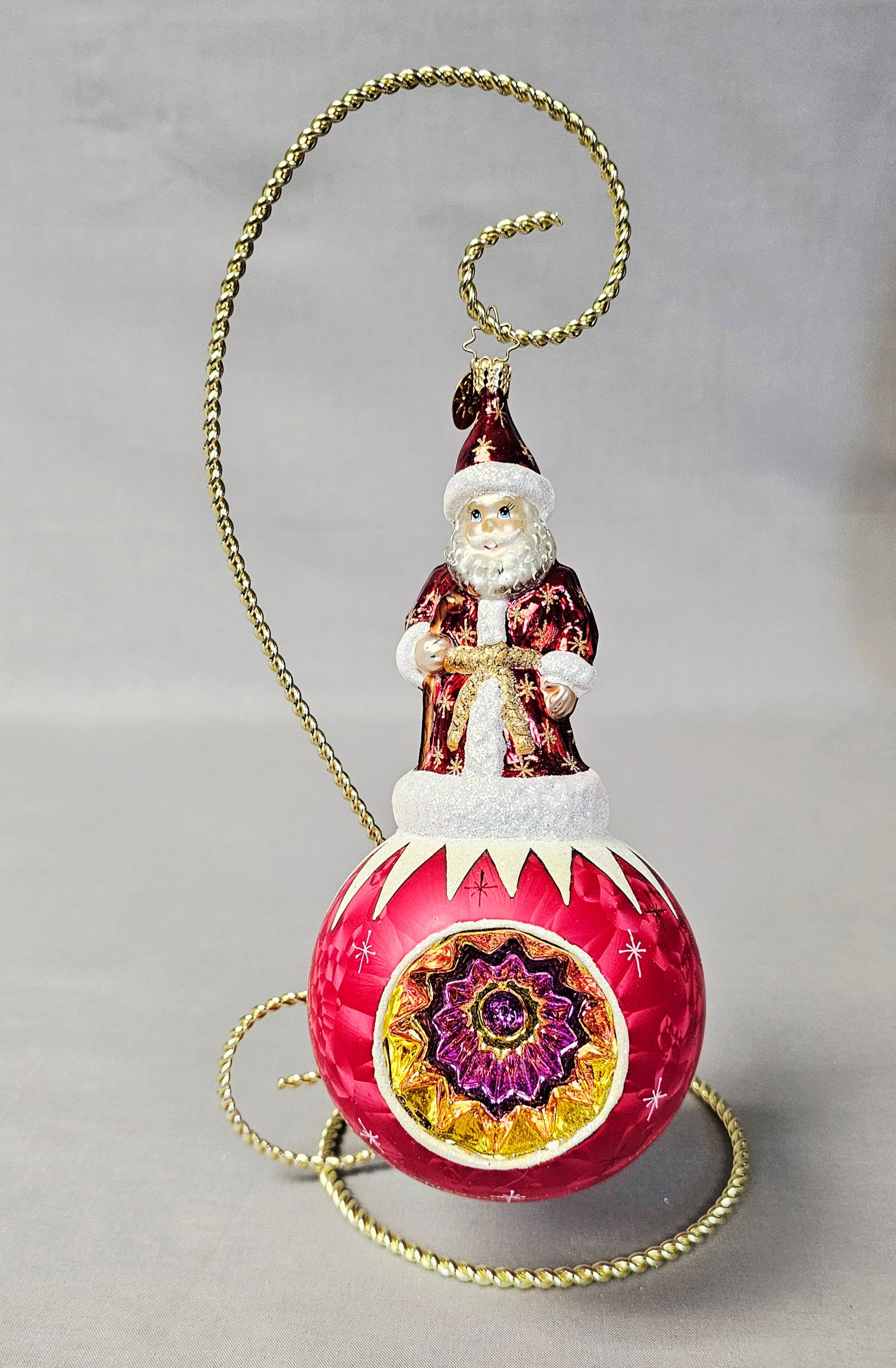Christopher Radko Glass Santa Claus Reflector Ornament: Stand not included. A large and ornate mouth-blown glass Christmas ornament by Christopher Radko, featuring a tiered design with a Santa Claus figure standing atop a spherical base. This item is in ex