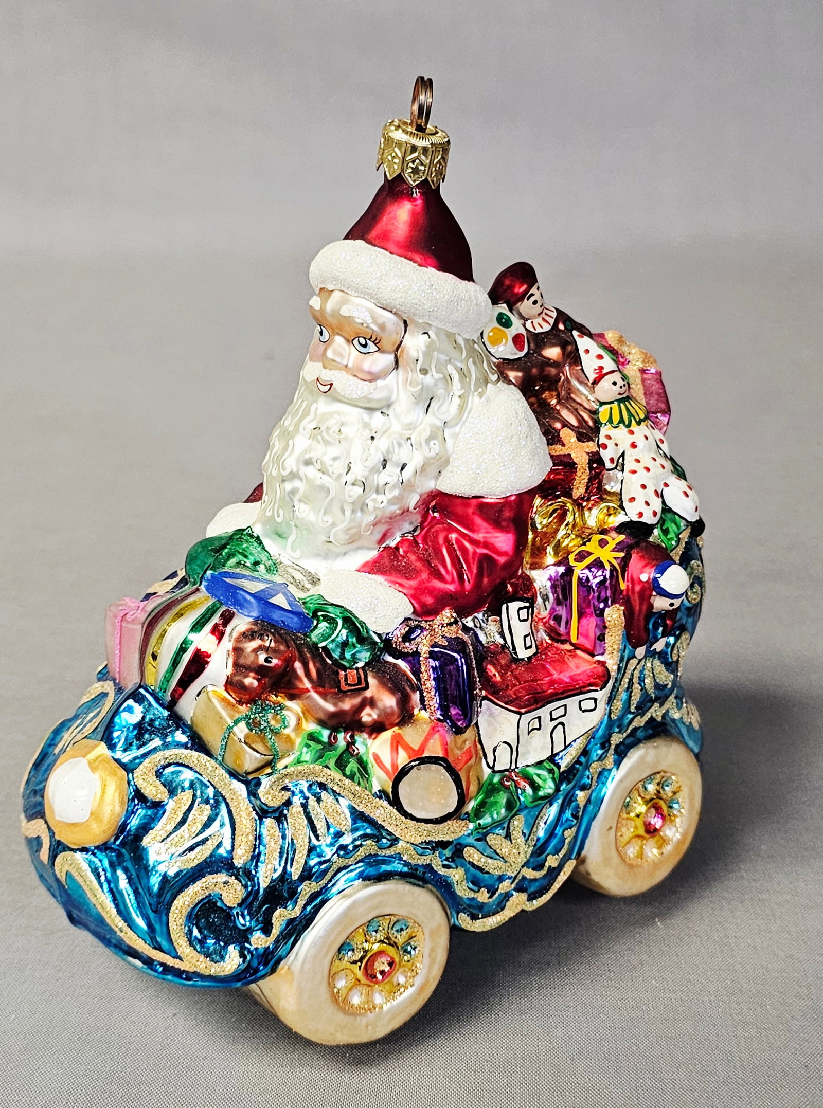 Christopher Radko Glass Santa Car Ornament 1999: A Christopher Radko hand-blown and hand-painted glass Christmas ornament depicting Santa Claus driving a vintage-style car. The ornament is in very good vintage condition. There are no observed chips,