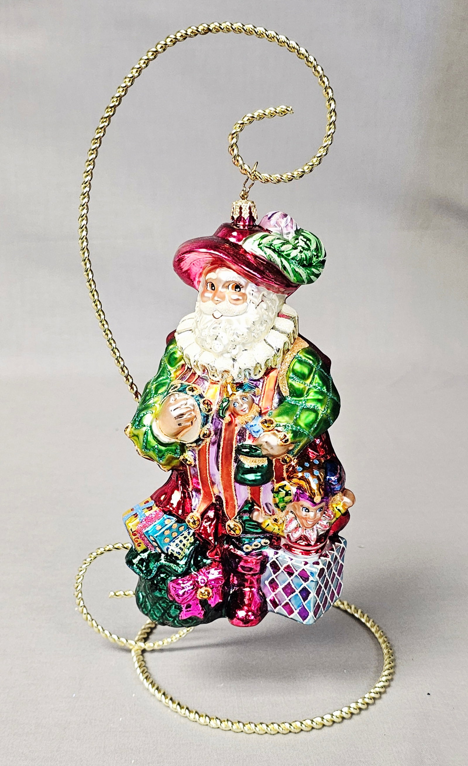 Christopher Radko Troubadour Tradition Santa Glass Ornament: Stand not included. A hand-blown glass Christmas ornament produced by Christopher Radko, titled Troubadour Tradition. This piece belongs to the Santa through the Centuries collection and represents an