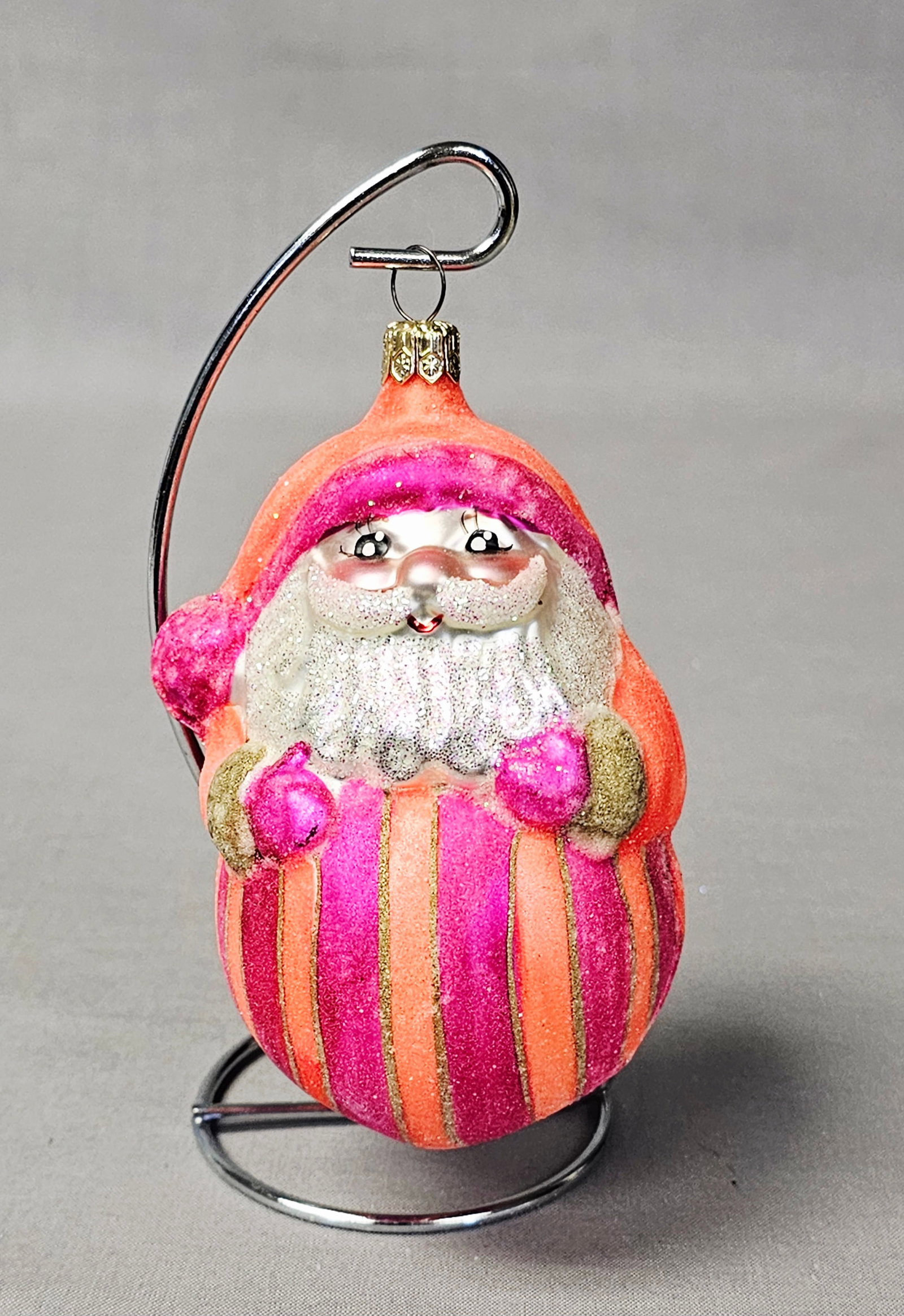 Radko Blown Glass Striped Santa Claus Ornament: Stand not included. A mouth-blown glass Christmas ornament in the form of a stylized Santa Claus, attributed to Christopher Radko. The figure features a vibrant color palette with alternating vertical
