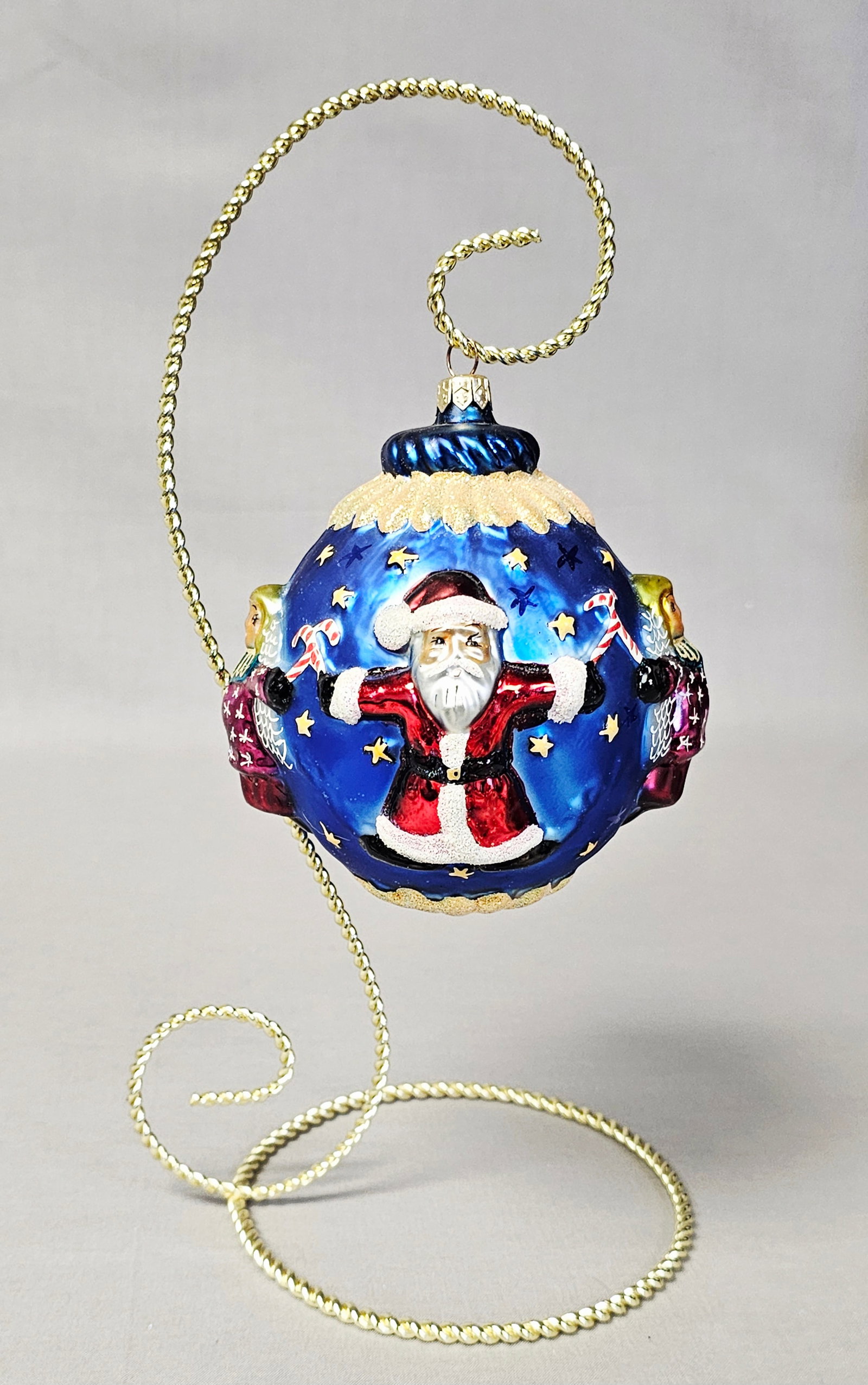 Christopher Radko Circle of Cheer Ornament: Stand not included. A large spherical mouth-blown glass Christmas ornament attributed to Christopher Radko. This ornament features multi-dimensional raised relief figures. The primary figure is Santa 