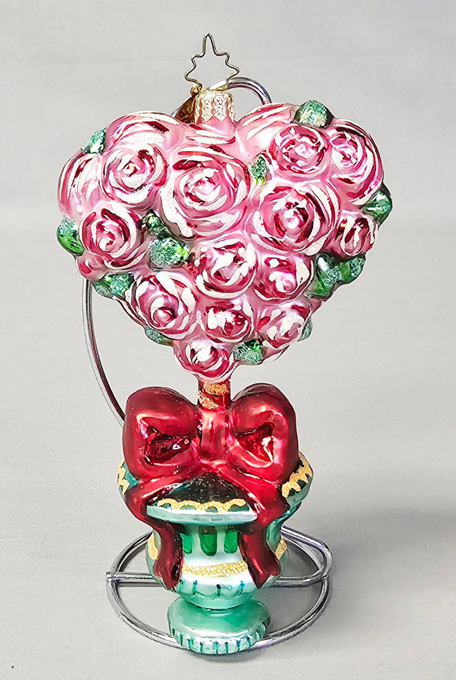 Christopher Radko Love in Bloom Rose Topiary Ornament: Stand not included. A Christopher Radko hand-blown glass holiday ornament titled Love in Bloom, designed as a floral topiary. The ornament features a large heart-shaped cluster of embossed roses in sh