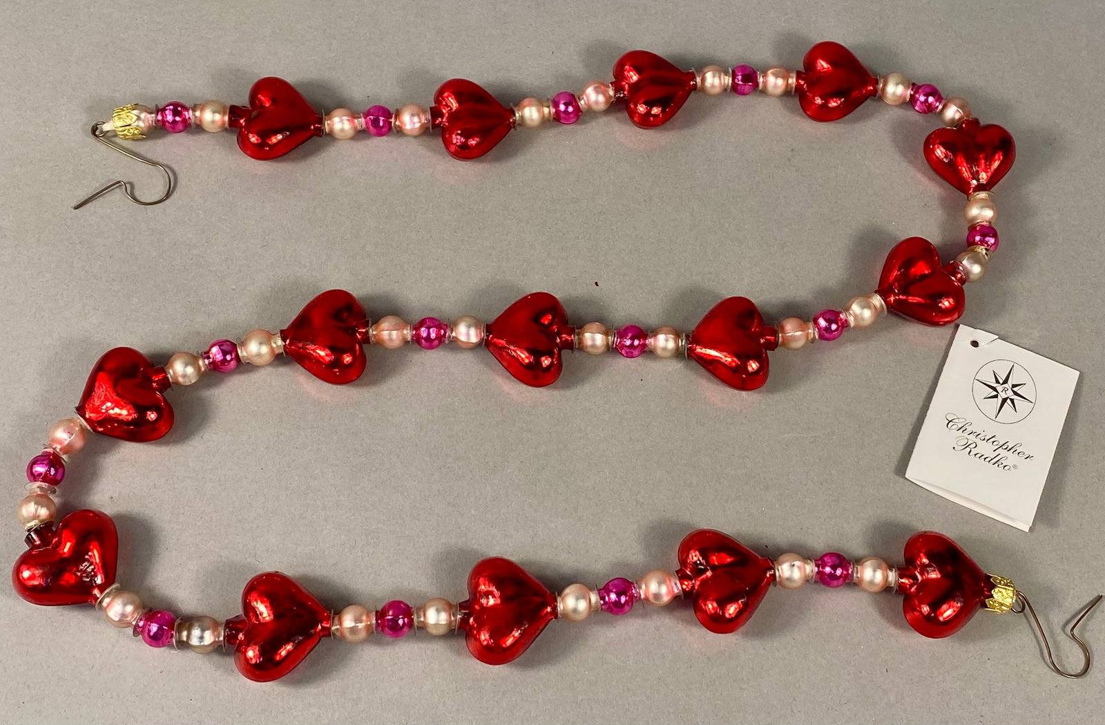 Radko Every Bead of My Heart Blown Glass Garland: This vintage Christopher Radko glass bead garland, titled Every Bead of My Heart (Model No. 99-151-0), features hand-blown glass components produced in Poland. The design includes a sequence of ruby r
