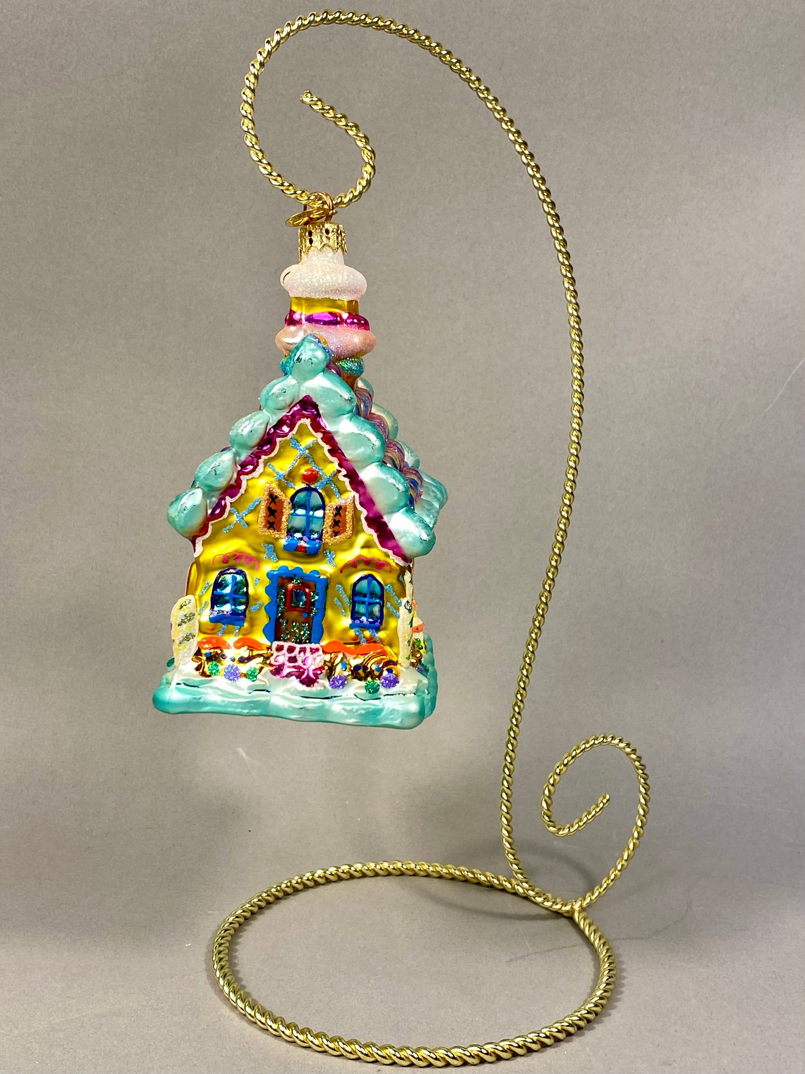 Radko Sweet Barn Delight Glass Ornament: A mouth-blown glass Christmas ornament by Christopher Radko, identified as the Sweet Barn Delight pattern. This holiday decoration is modeled as a whimsical gingerbread cottage featuring a bright yell