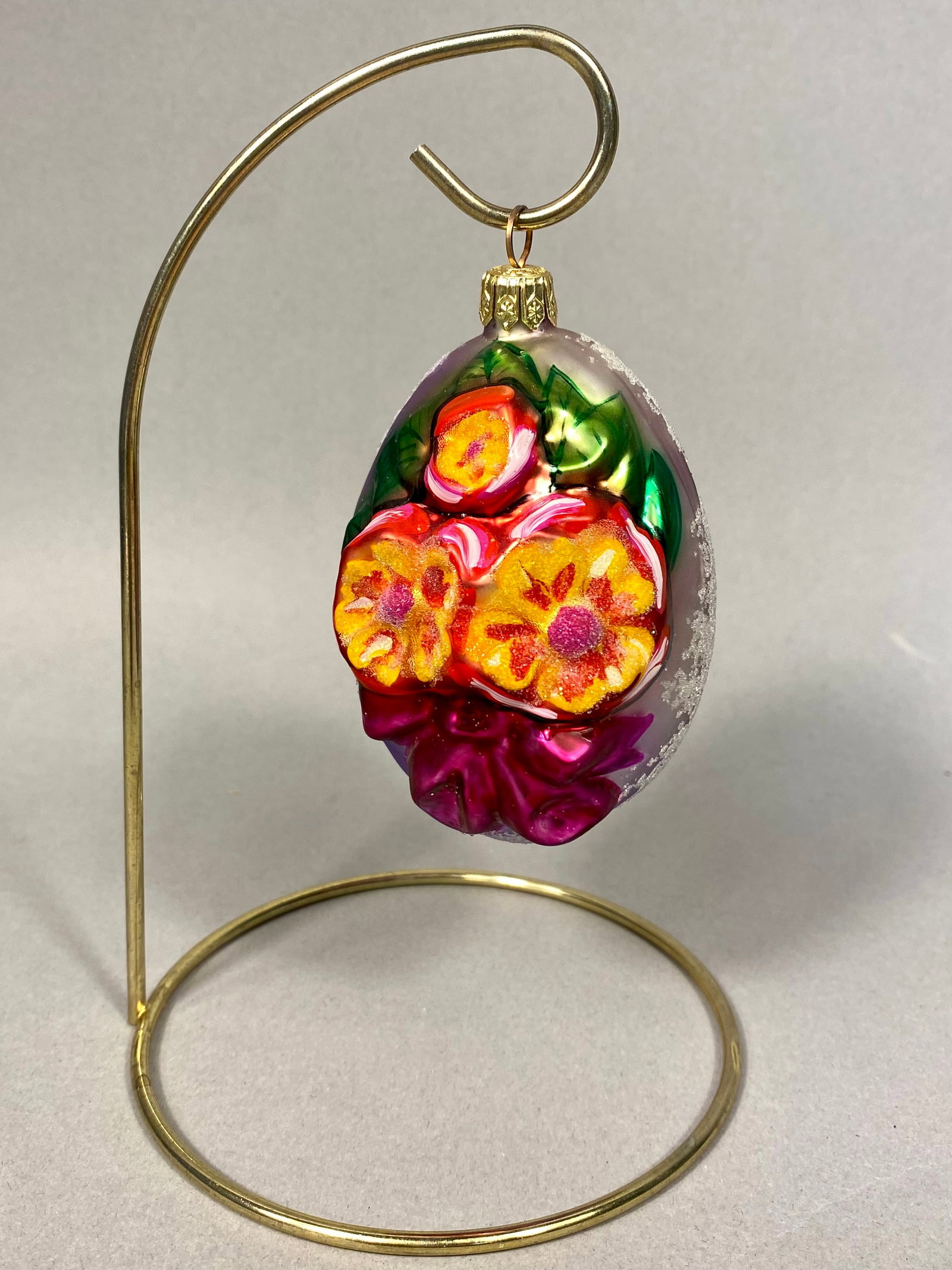 Radko Flowery Reflections Hand-Blown Glass Floral Egg Ornament: This Christopher Radko hand-blown glass ornament is identified as the Flowery Reflections pattern. The egg-shaped ornament features high-relief, embossed floral motifs including three vibrant yellow a