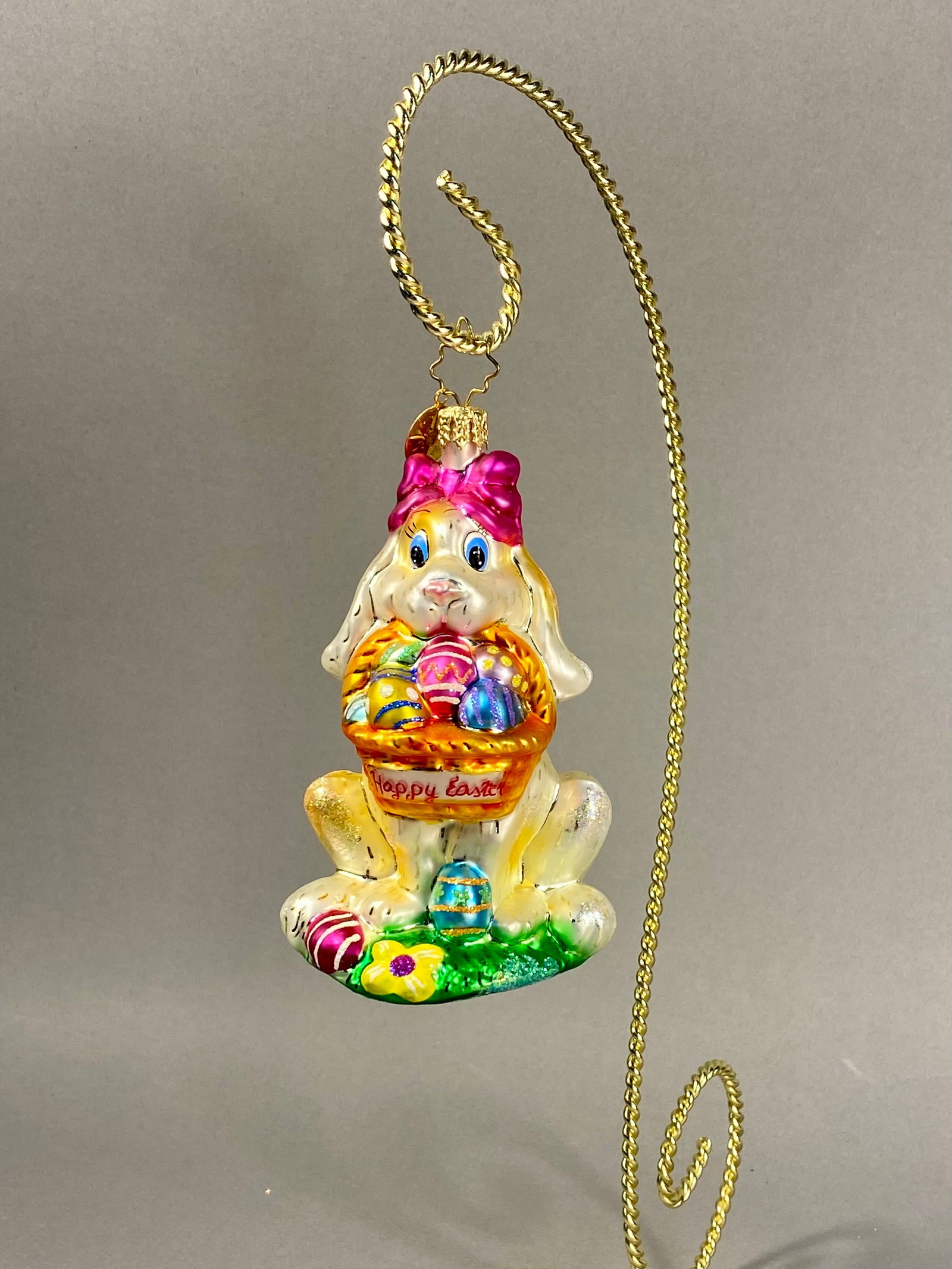 Radko Billy Bunny Goes Shopping Ornament: **Stand Not Included** This mouth-blown tempered glass ornament is a Christopher Radko production titled Billy Bunny Goes Shopping. The piece features a seated rabbit with creamy white and pale yellow