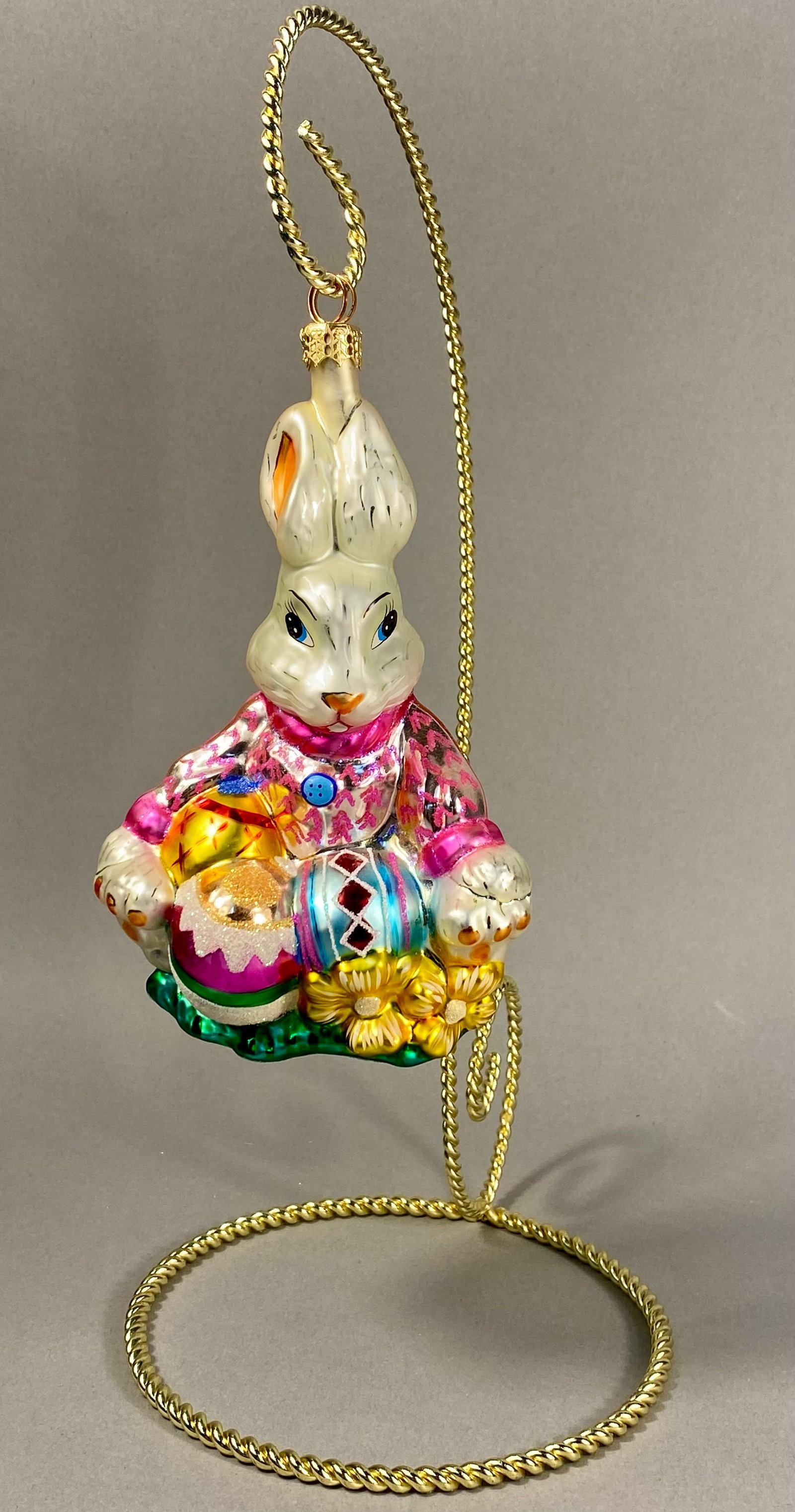 Radko Mouth Blown Glass Easter Bunny Ornament: **Stand Not Included** A mouth-blown glass Easter bunny ornament by Christopher Radko depicting a white rabbit in a pink jacket holding decorated eggs. Height: 5.5 inches. Excellent