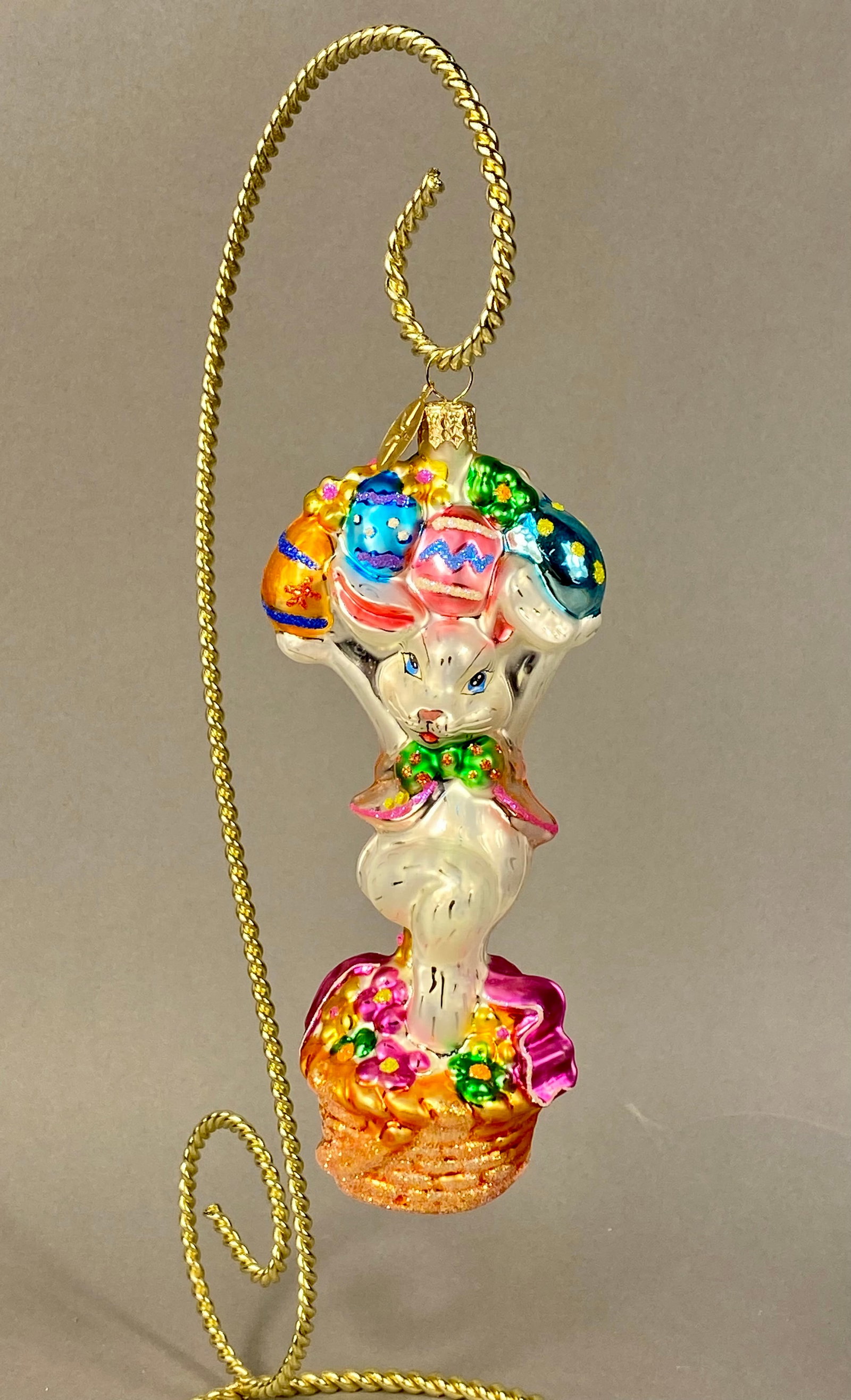 Christopher Radko Mouth-Blown Glass Easter Bunny Ornament: This mouth-blown glass holiday ornament is a Christopher Radko design featuring an Easter rabbit motif. The piece depicts a standing white rabbit wearing a pink-trimmed jacket and a green polka-dot bo