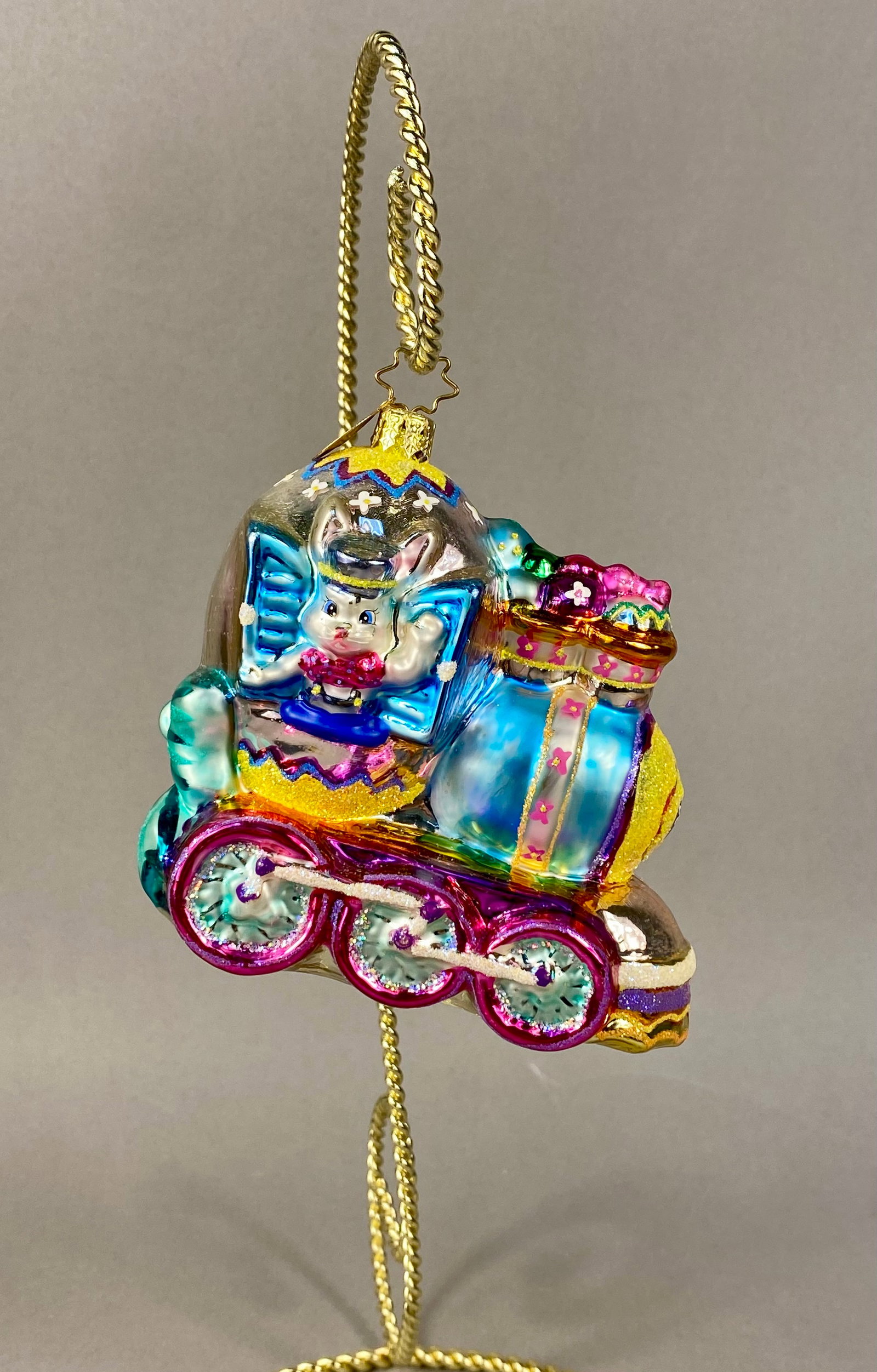 Christopher Radko North Pole Junction Little Gem Glass Ornament: A Christopher Radko mouth-blown glass holiday ornament titled North Pole Junction from the Little Gems collection. The ornament is shaped like a whimsical steam locomotive and features a rabbit engine