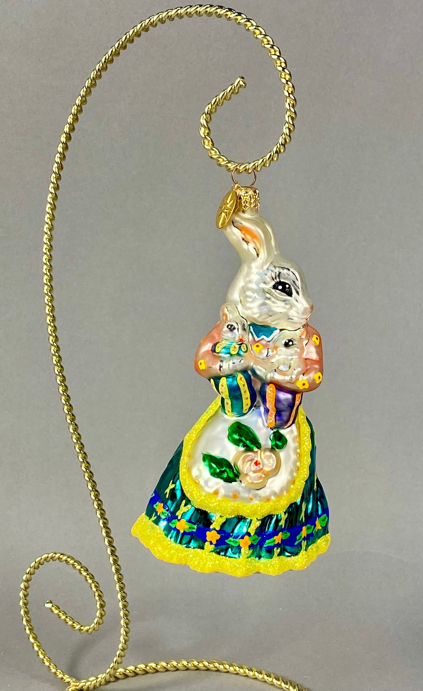 Christopher Radko Hand-Painted Glass Mother Rabbit and Babies Ornament: A mouth-blown tempered glass holiday ornament produced by Christopher Radko, featuring a mother rabbit holding two baby rabbits. The mother rabbit is rendered with a pearlescent white finish and hand-