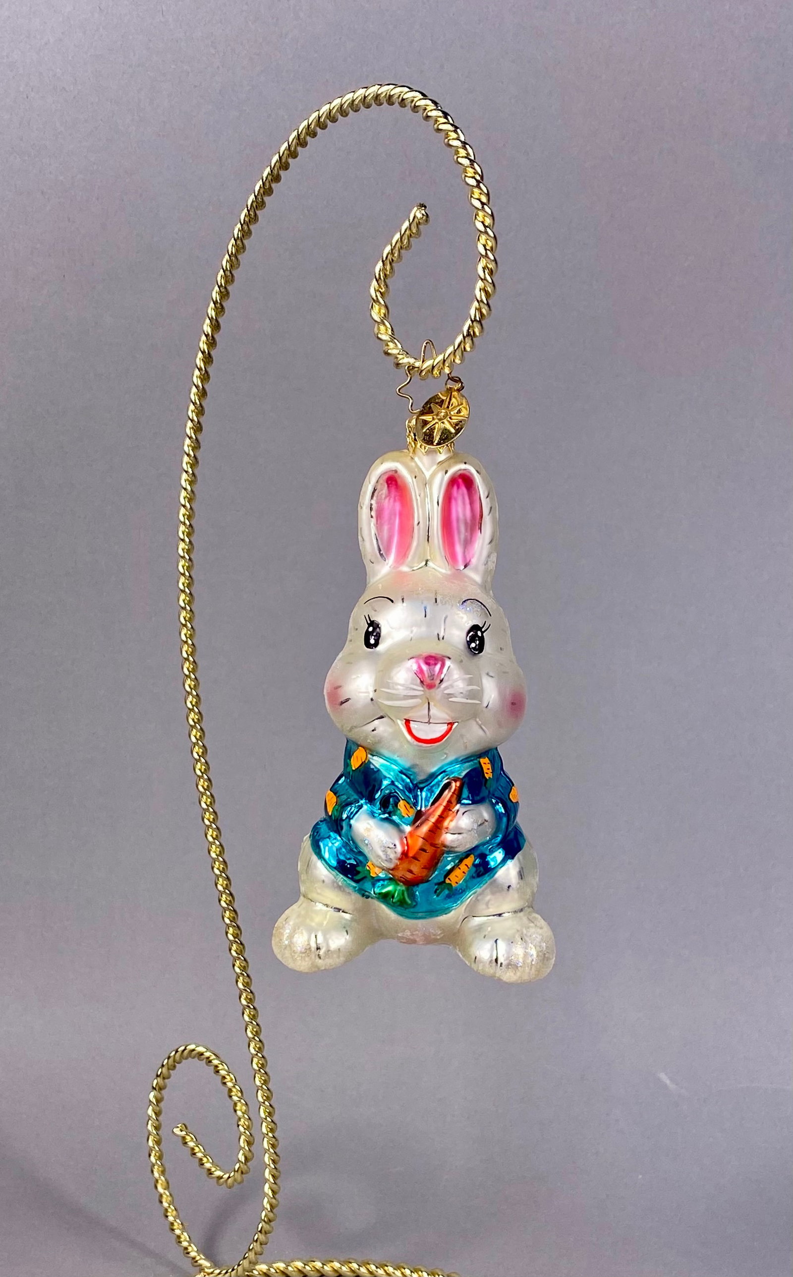 Christopher Radko Hoppy Holidays Glass Bunny Rabbit Christmas Ornament: This is a mouth-blown glass figural ornament produced by Christopher Radko, identified as the Hoppy Holidays model. The ornament depicts a standing bunny rabbit with a white pearlescent finish and iri
